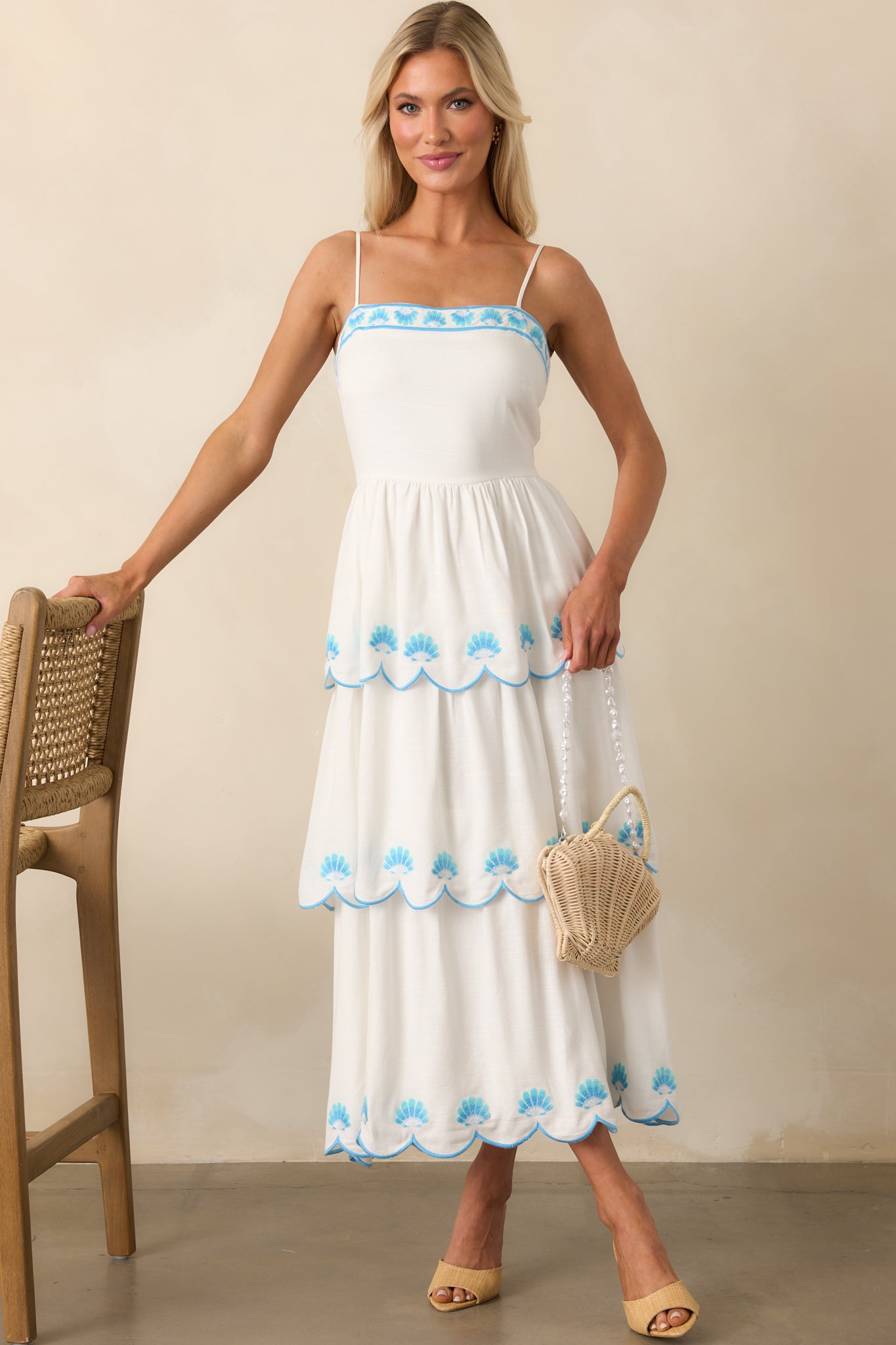 Frontal image showcasing the structured bodice and delicate blue embroidery across the skirt tiers.
