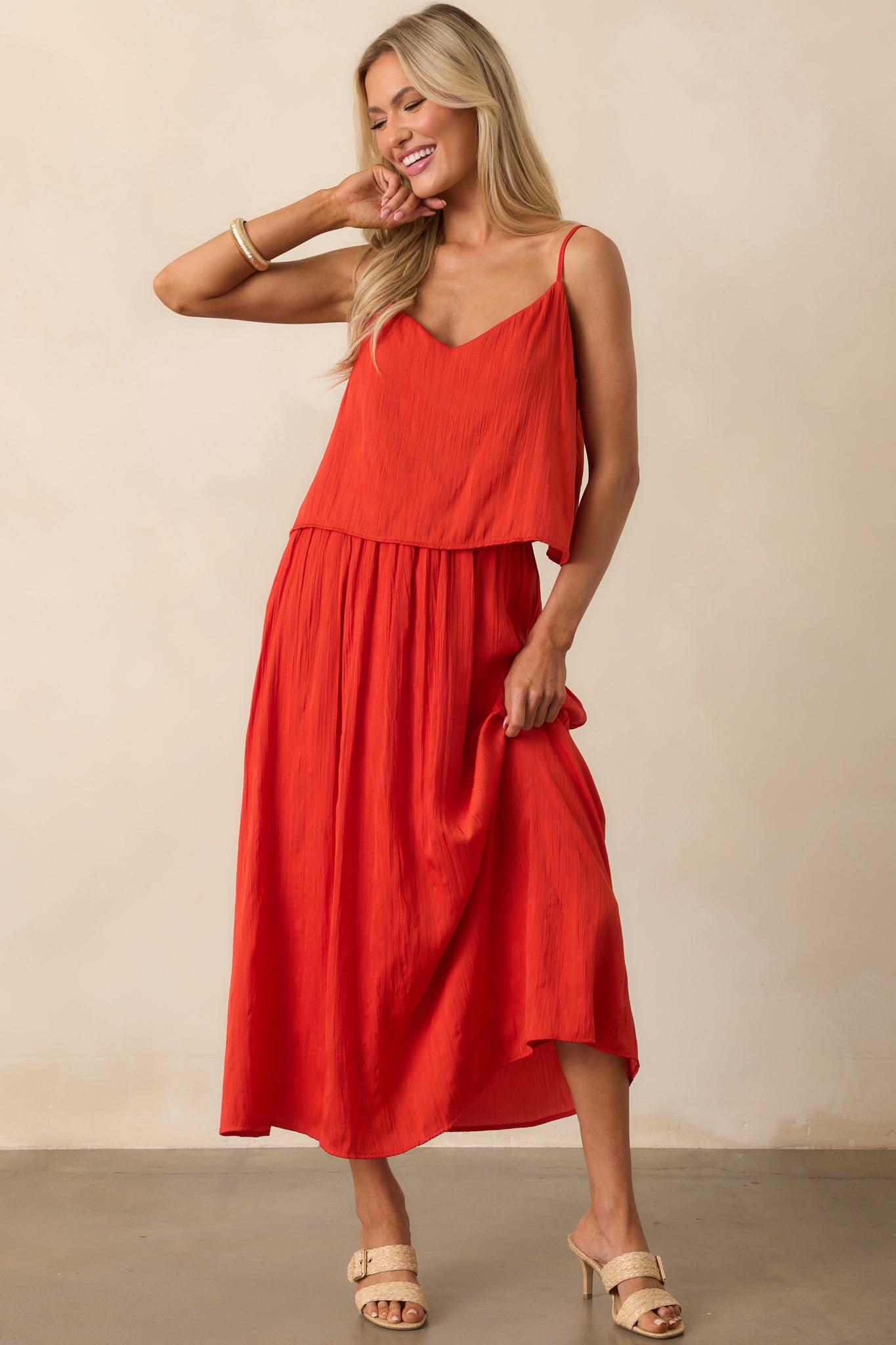 Full view of the red satin top, showcasing its v-neckline, adjustable straps, and slightly relaxed fit.