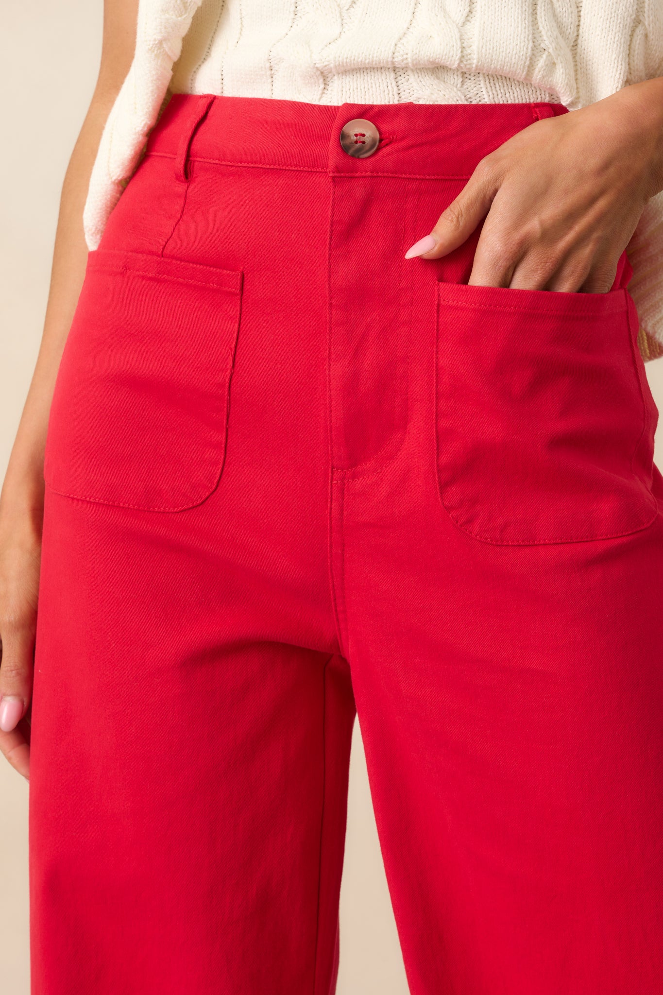 Zoomed-in view of the button and zipper closure, showing the texture of the tortoise shell and clean topstitching.