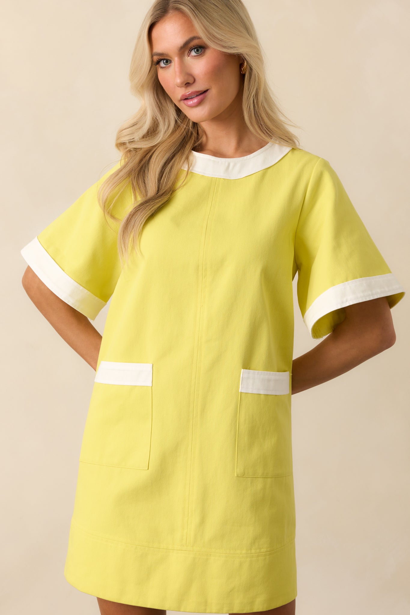 Cropped image showing the neckline and sleeve seam with white trim detail.