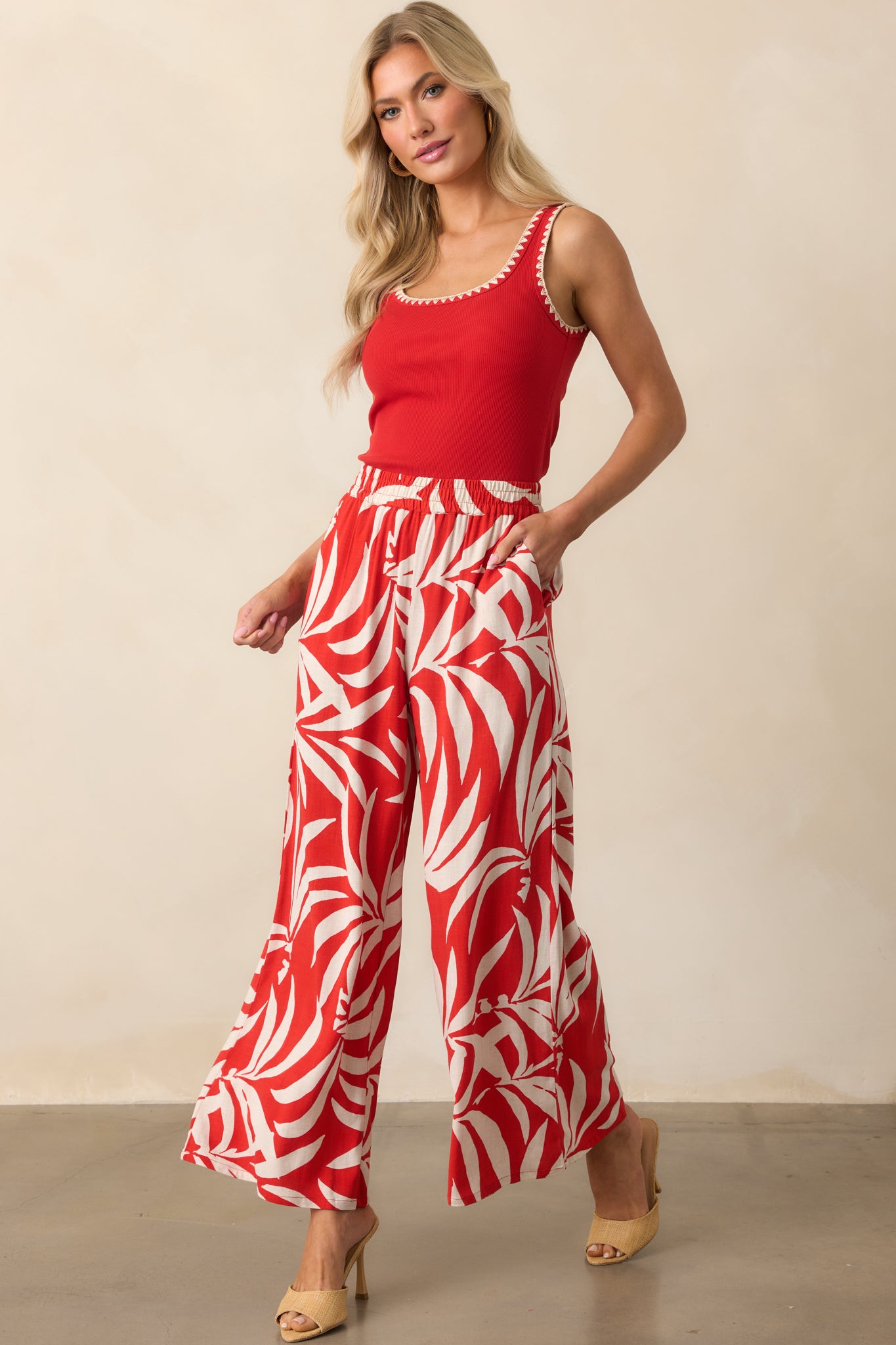Lightweight red pants featuring a bold ivory print and breezy fit, shown styled to highlight their fluid movement.