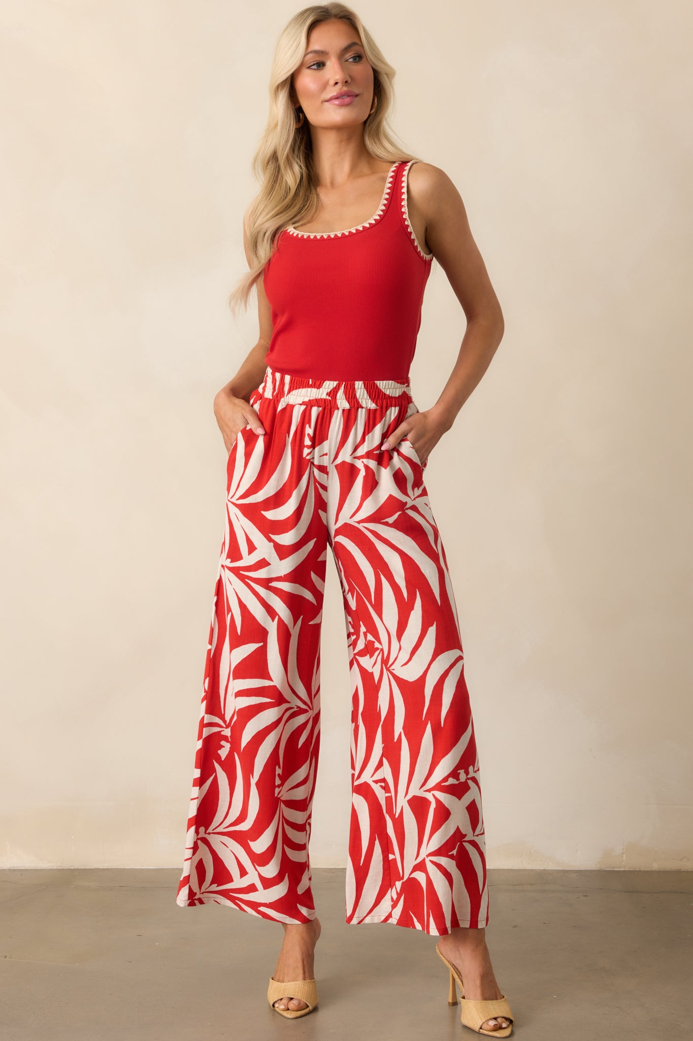 Red scoop-neck top in a full-body view, highlighting the sleeveless design and beige stitching accents.