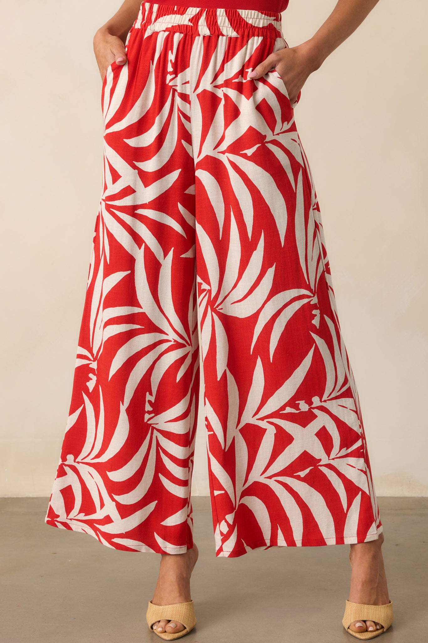 Close-up of the fabric showing the ivory tropical pattern in sharp detail against the red background.