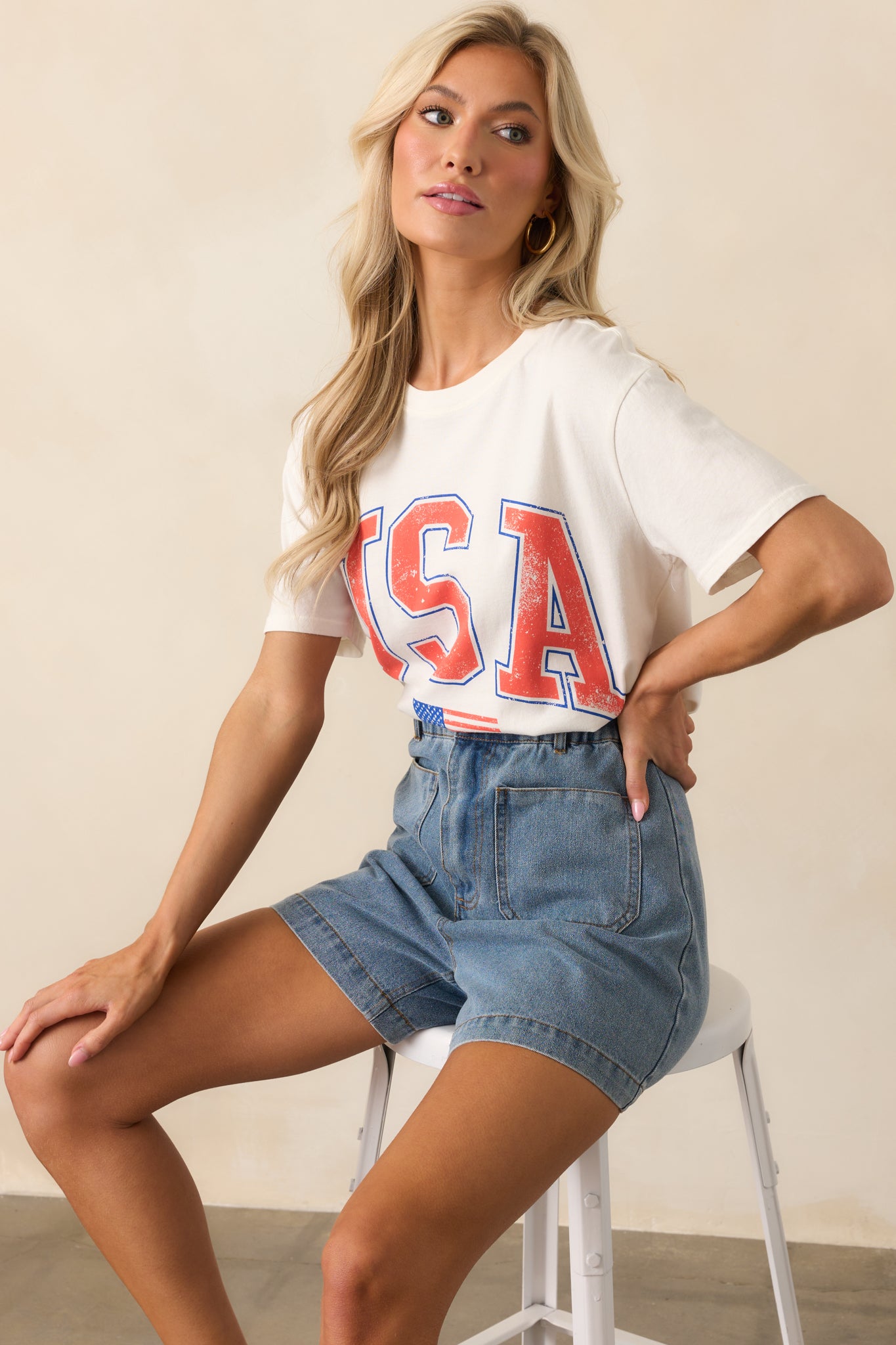 Ivory short-sleeve tee with a crew neckline and bold 'USA' graphic displayed in a casual, full body shot.