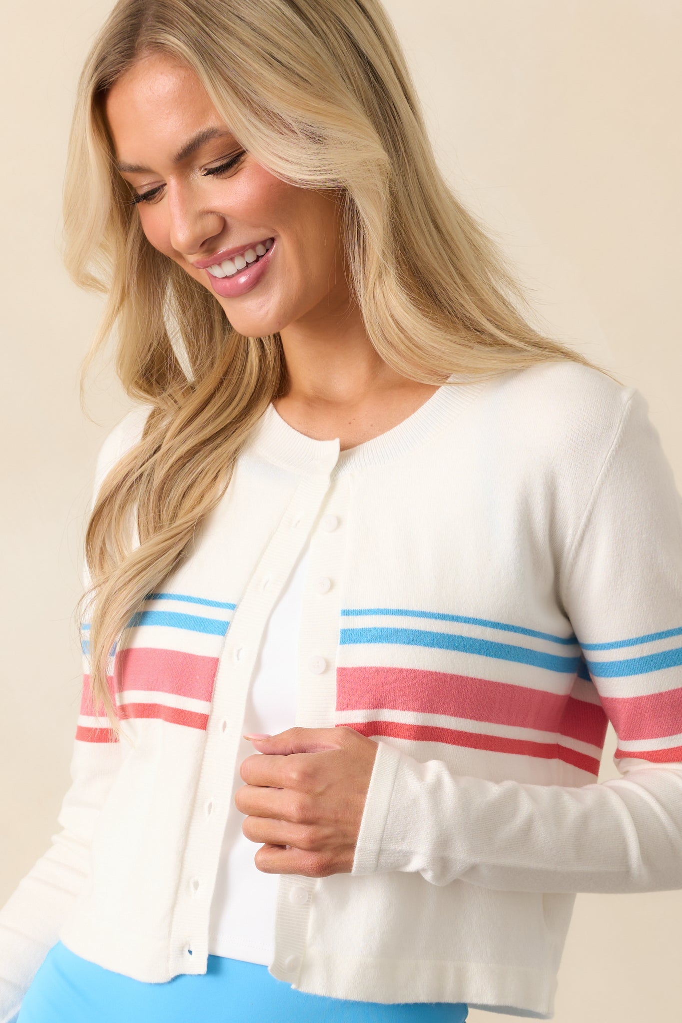 Focused view highlighting the red and blue stripe accents along the hem of the cropped cardigan.