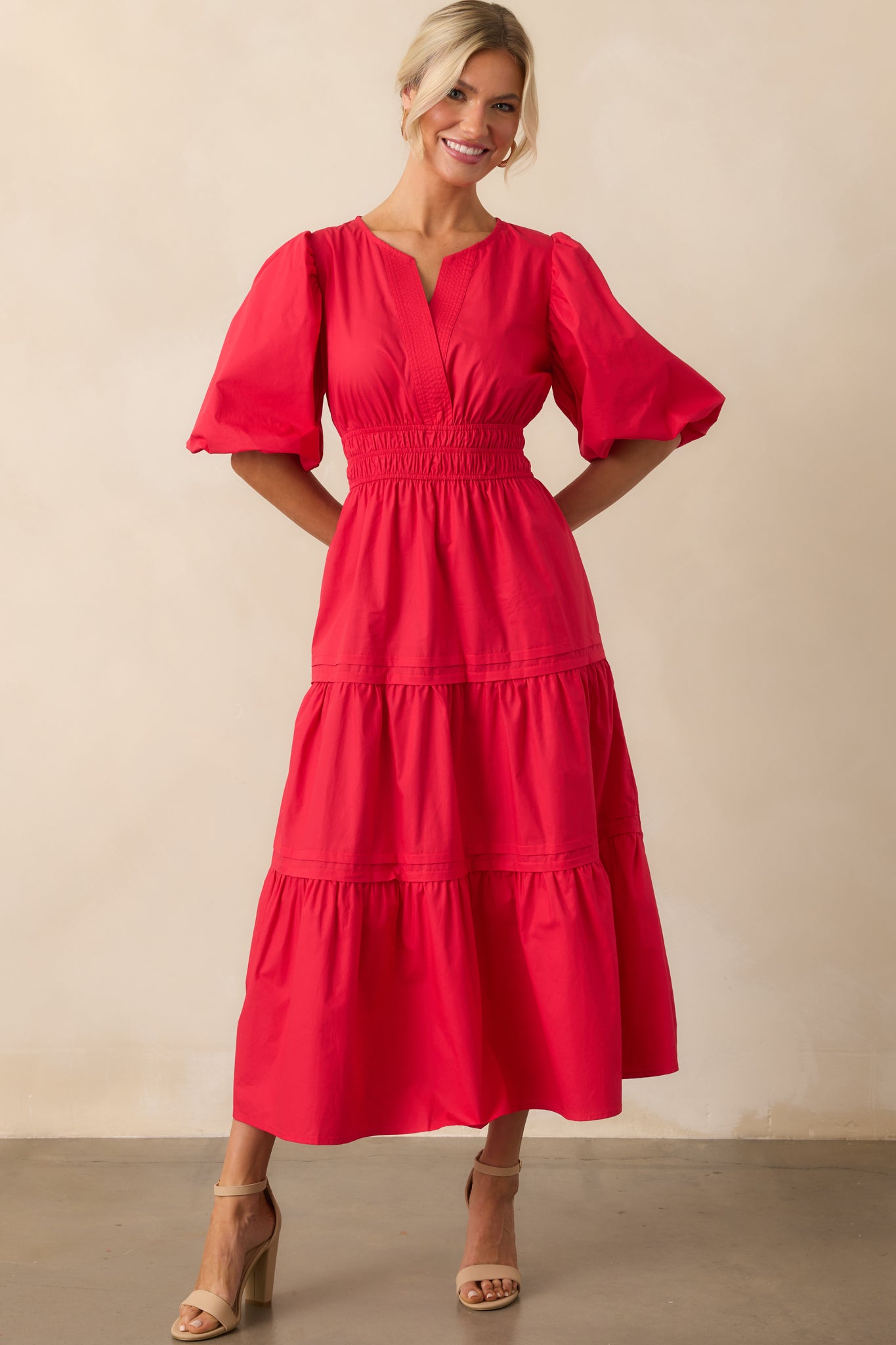 A straight-on view showcasing the full length and silhouette of the red maxi dress with a defined waist detail.