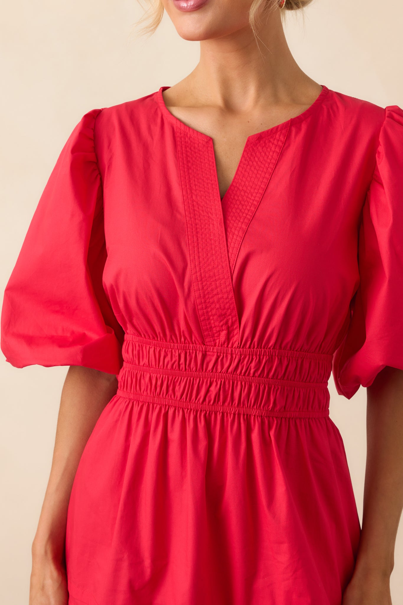 A zoomed-in shot of the notch v-neckline with a hidden snap button and the gathered detail at the shoulders.