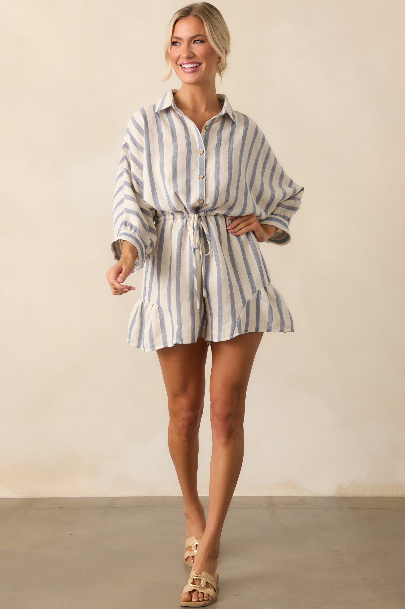 A complete profile of the striped romper highlighting the relaxed fit and cuffed 3/4 length sleeves.
