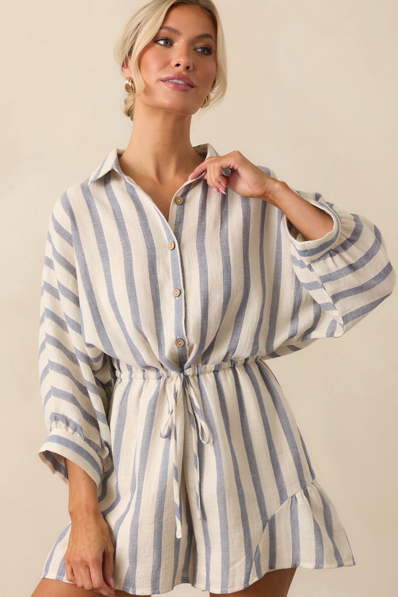 A close-up crop of the romper showing the collared neckline, buttons, and stripe pattern.