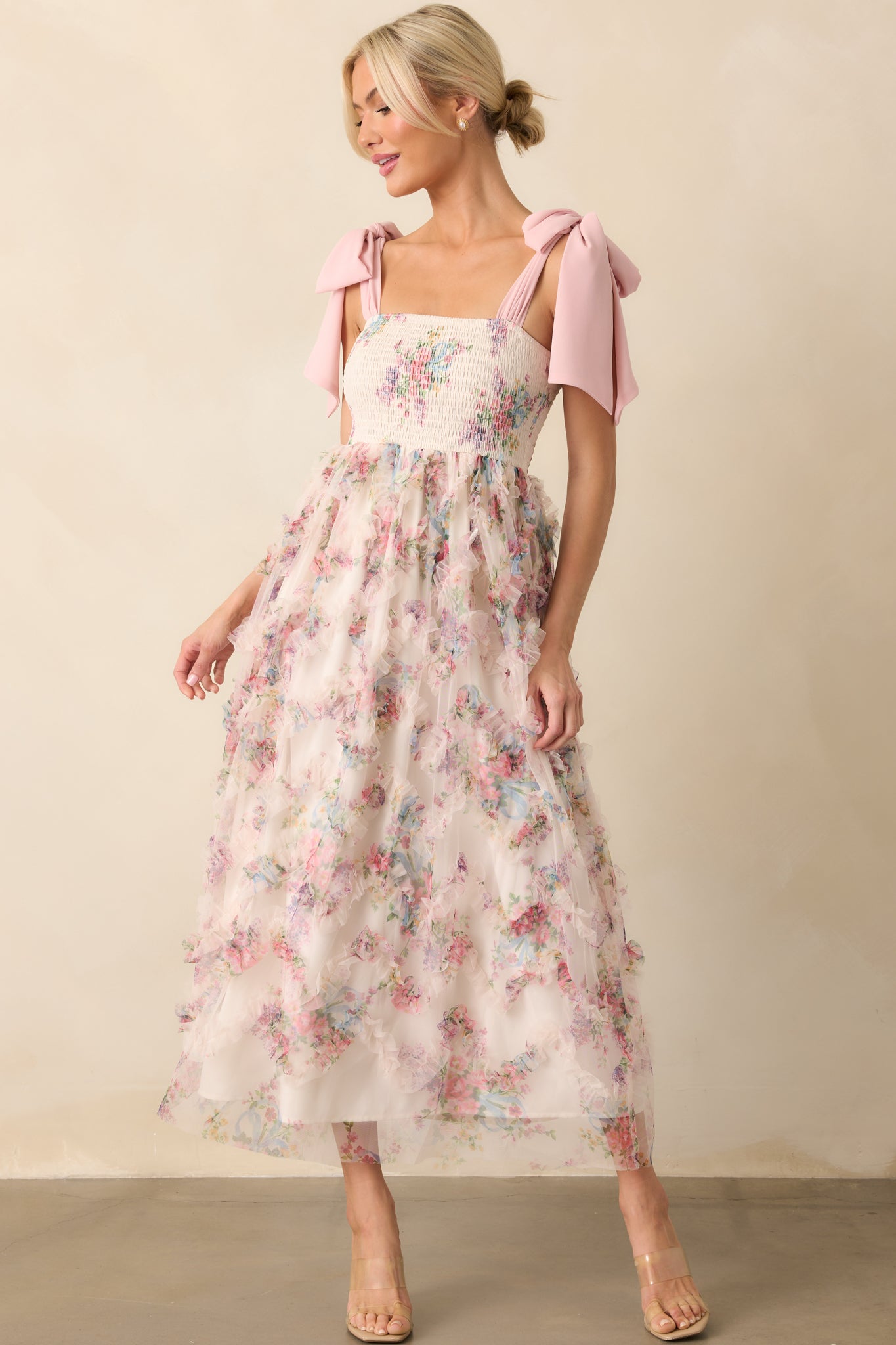 Full body front view of the maxi dress showing the sheer pink multicolor floral print overlay, square neckline, and fully smocked bodice over an ivory lining.