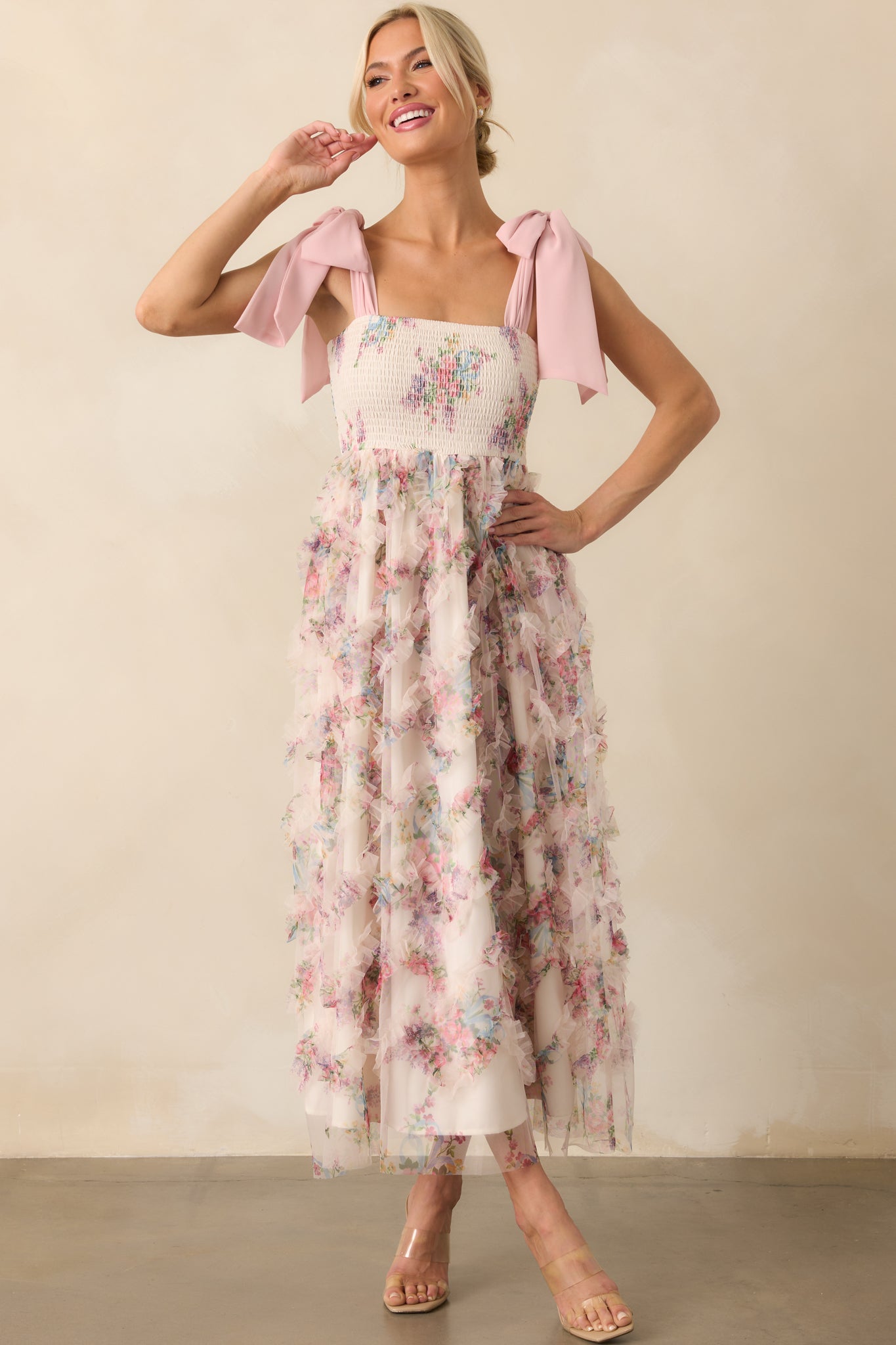 Full body view with a closer front-facing perspective focusing on the smocked bodice and soft floral print detail across the overlay.