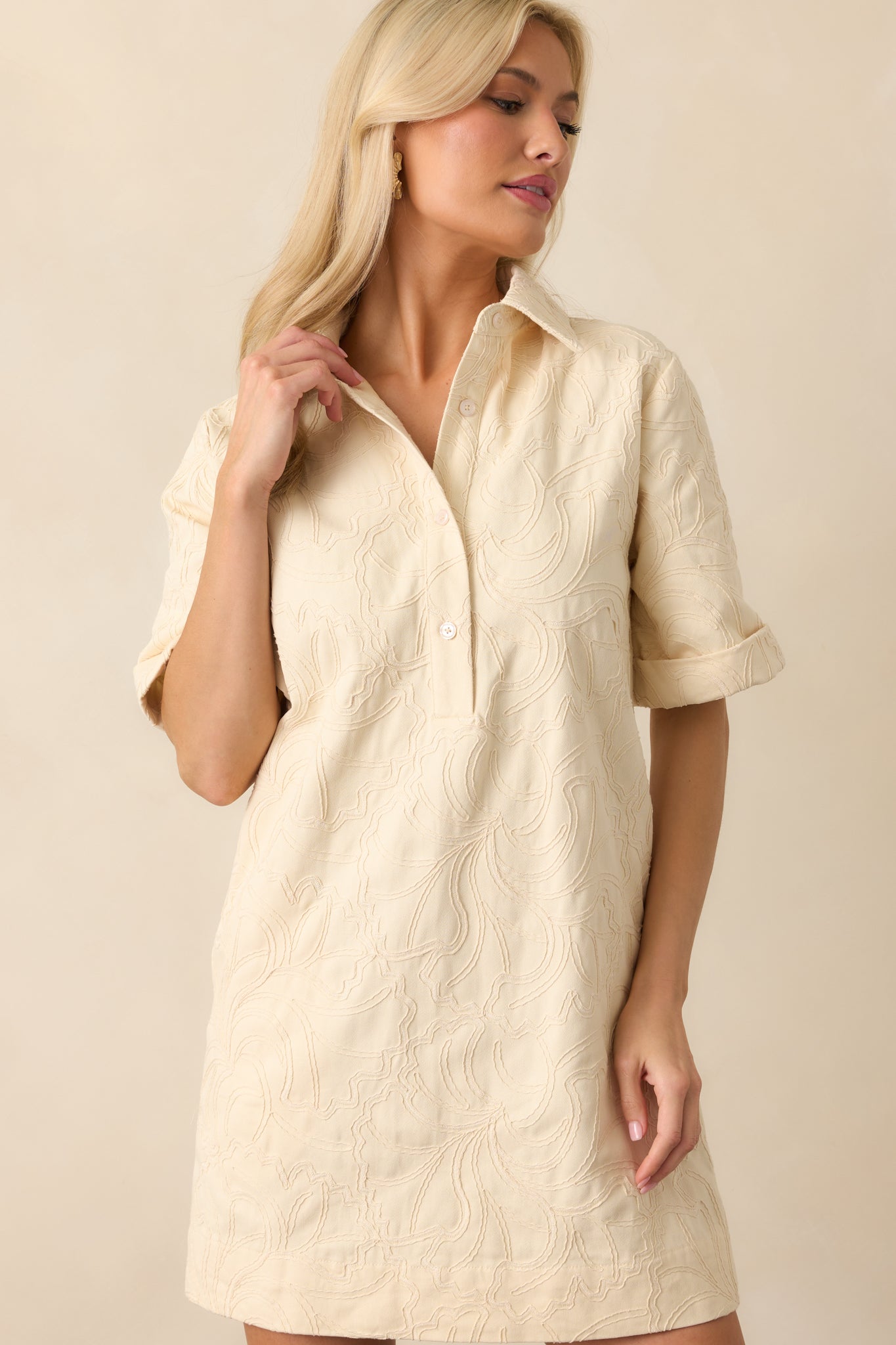 Zoomed-in upper section of the dress showing the collar, button placket, and embroidered floral patterns across the chest.