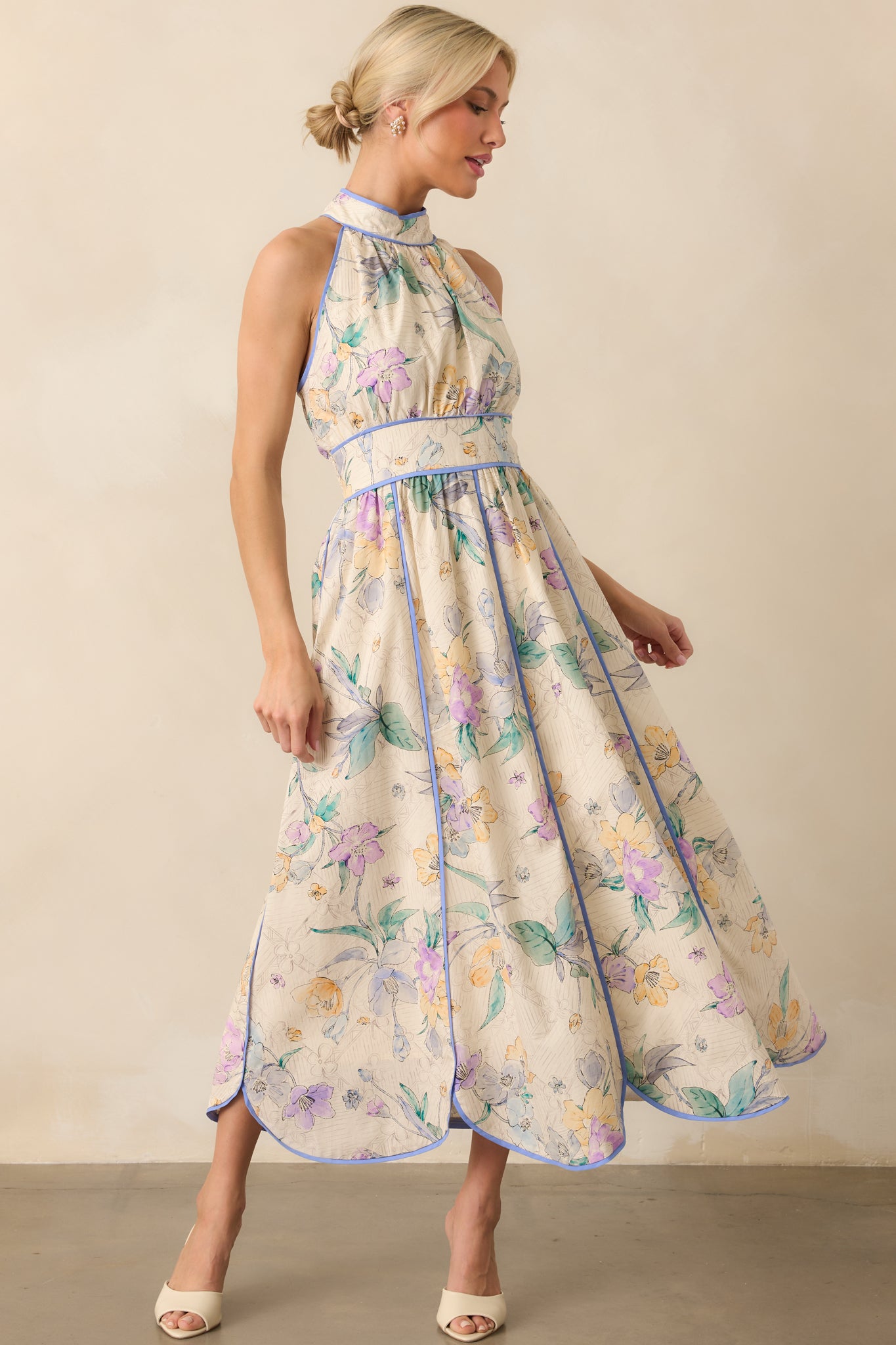 Full body front angle from the left, capturing the movement of the panel skirt and the curved shape of the scalloped hem.