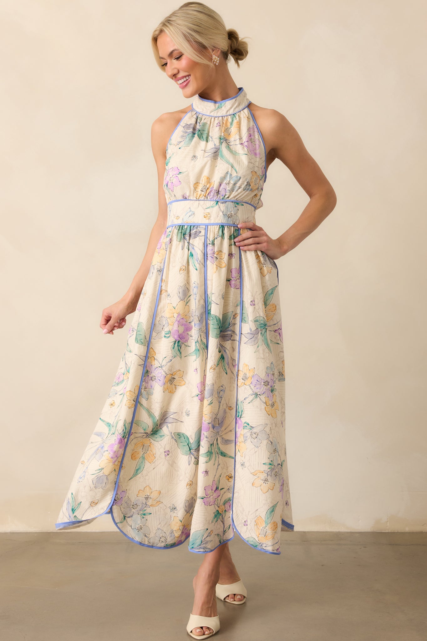 Full body front view of the ivory maxi dress showing the multicolor floral print, ruched bodice, and halter neckline with blue trim accents.