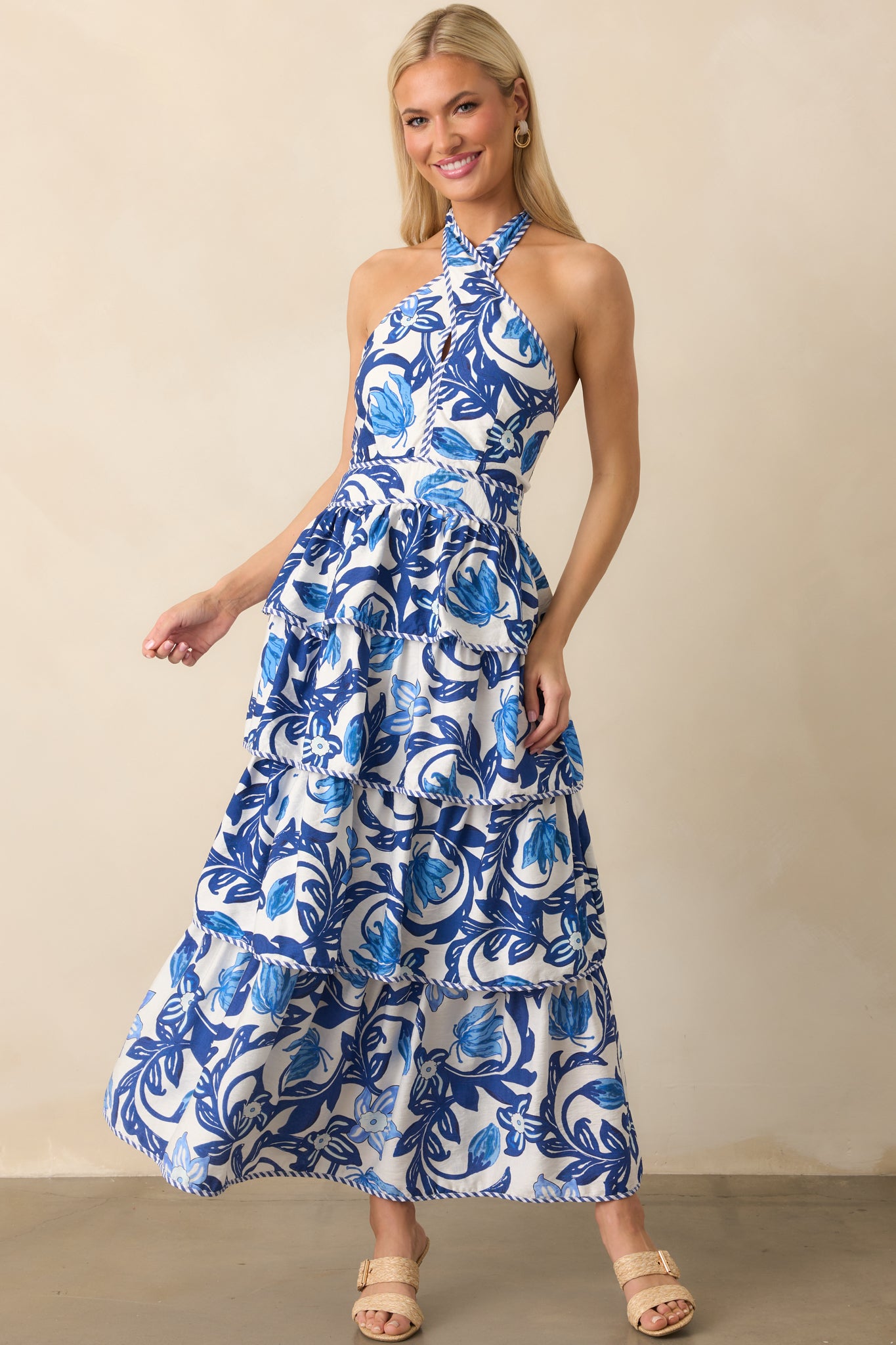 Three-quarter front angle showing the blue and white stripe trim detailing across the neckline and tiers of the skirt.
