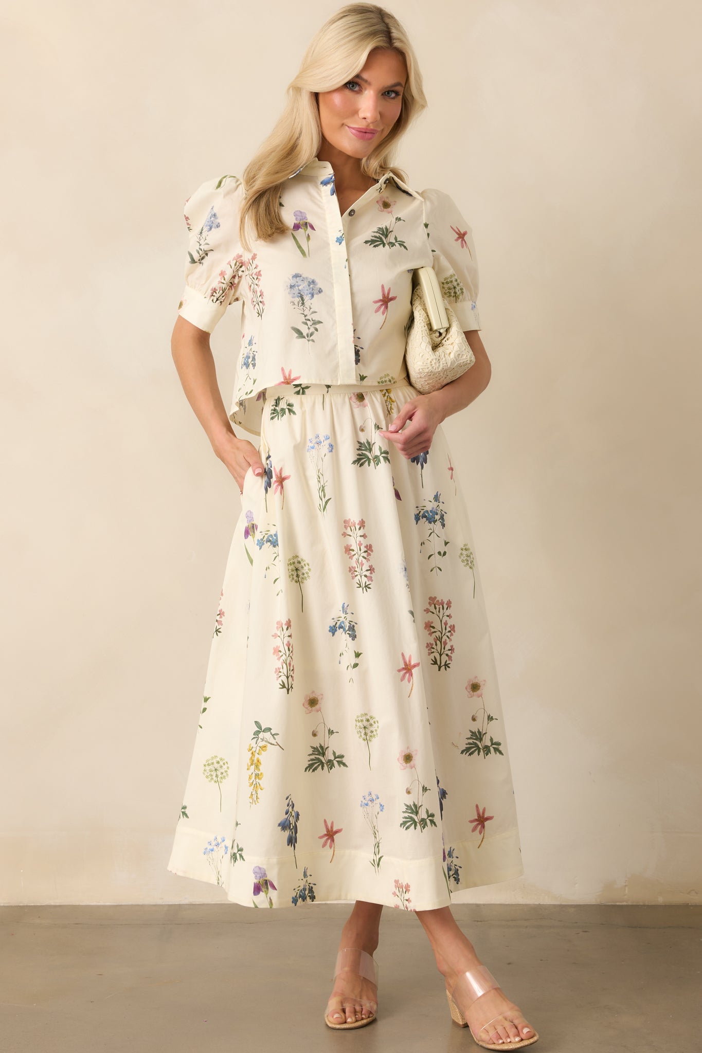 Full body view of an ivory top with a multicolor floral print, styled with a collared neckline and a slightly cropped, relaxed fit.