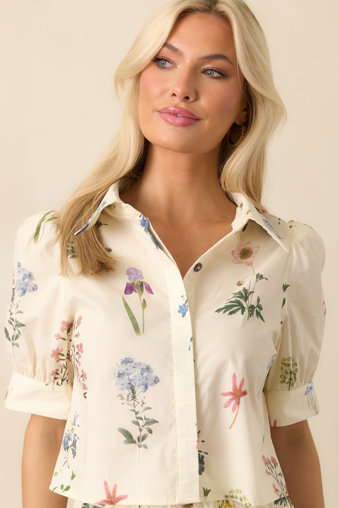 Close-up of the front buttons on the ivory floral top, showcasing the functional detail and texture of the fabric.