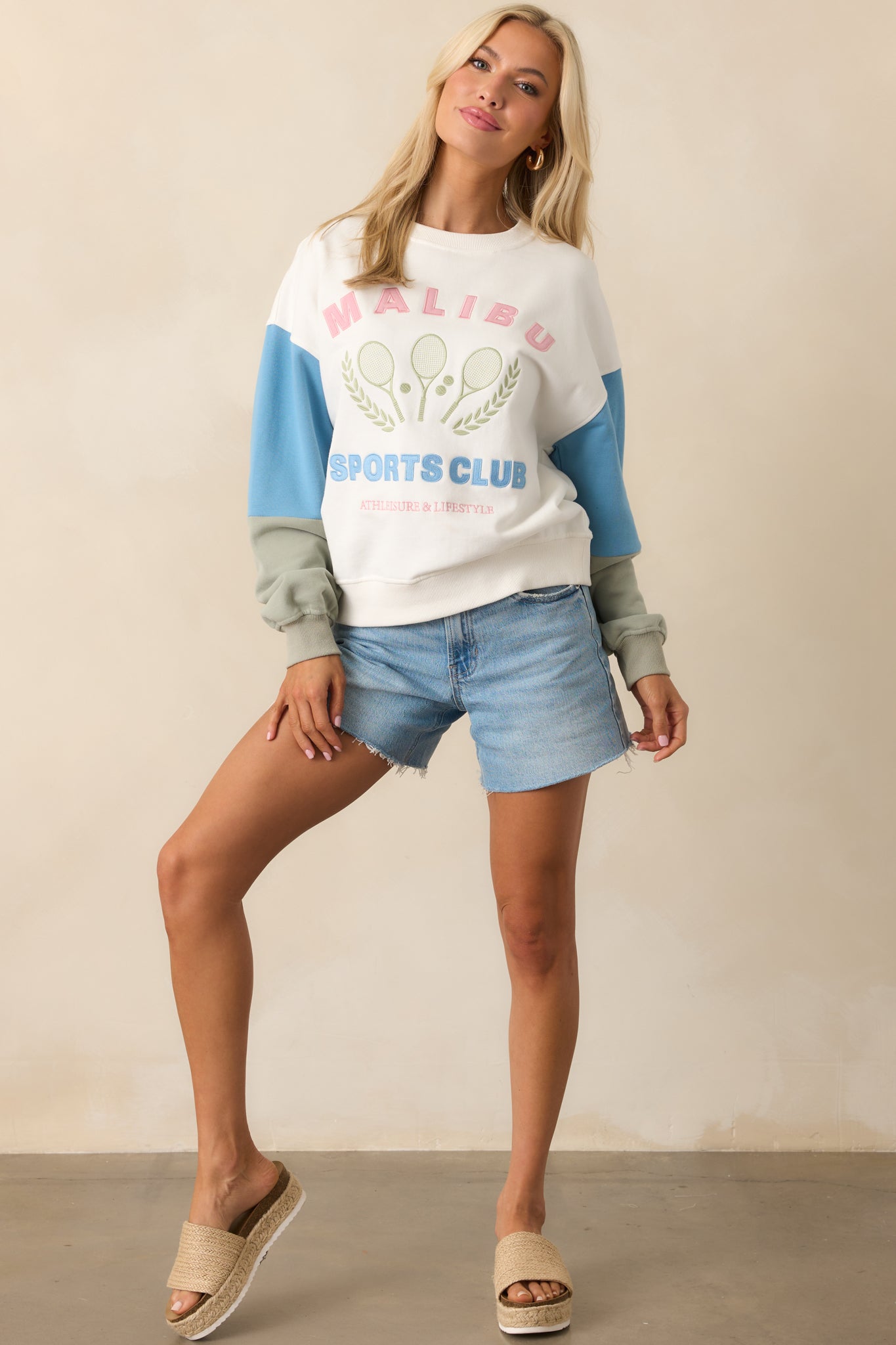 Full body shot highlighting the relaxed fit and full length of the sweatshirt, with the contrasting sleeve colors clearly visible.