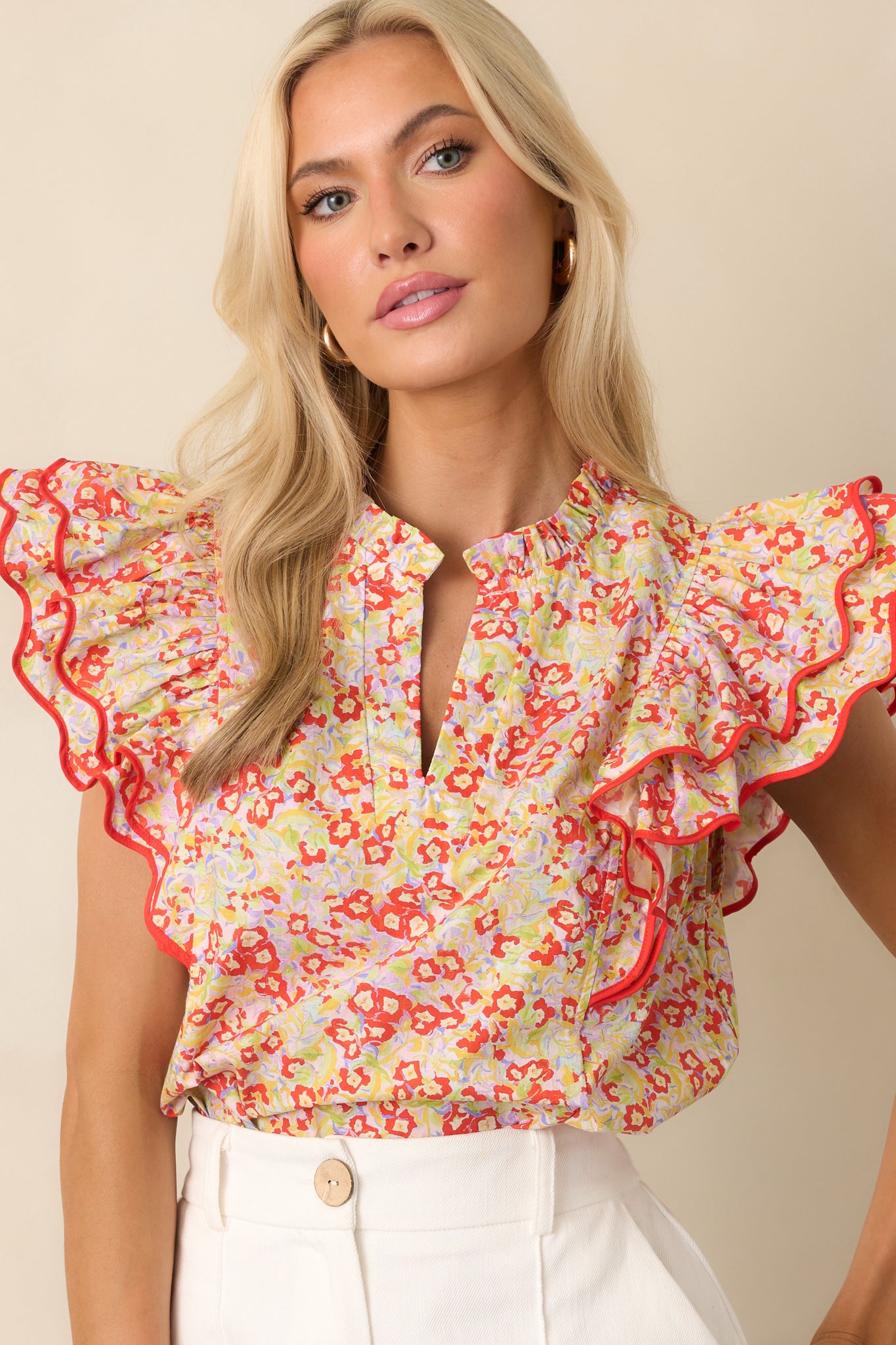 A cropped view focusing on the ruffled collar and notch v-neckline, with floral detailing visible along the chest.