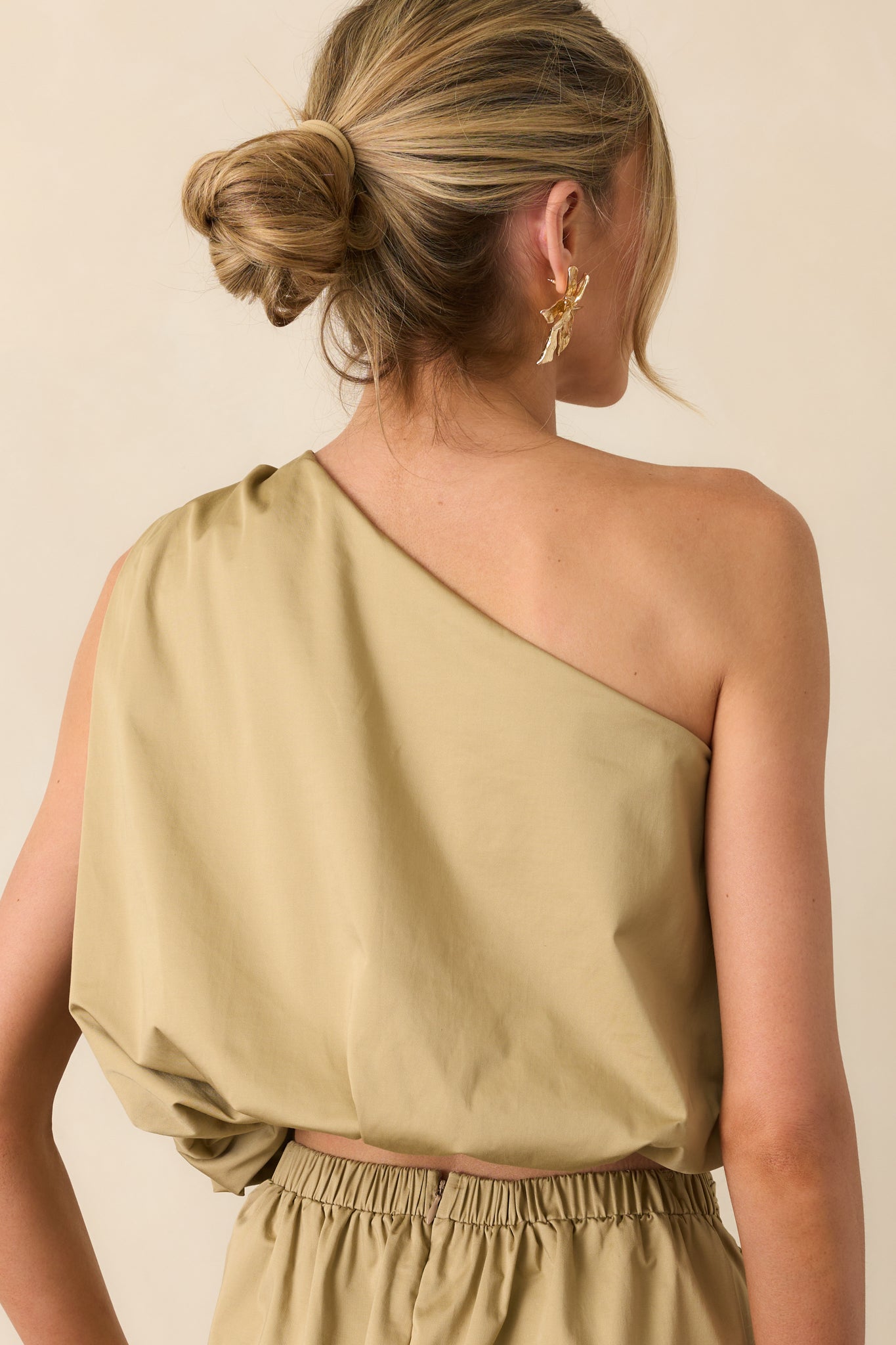 Back view of the top showing the continuation of the one shoulder neckline and clean finish across the back panel.