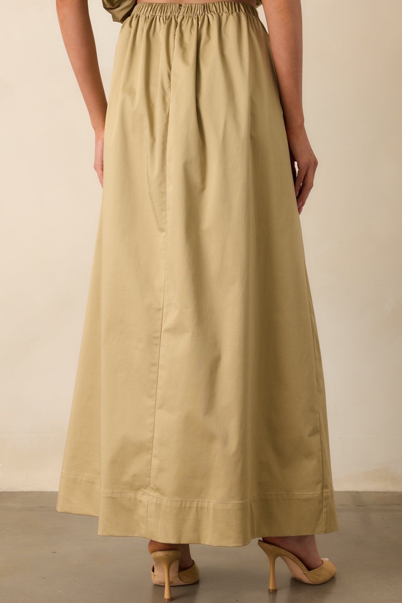 Close-up of the ruched waistband and 3D gold embellishment, showing the intricate texture and fabric detail.