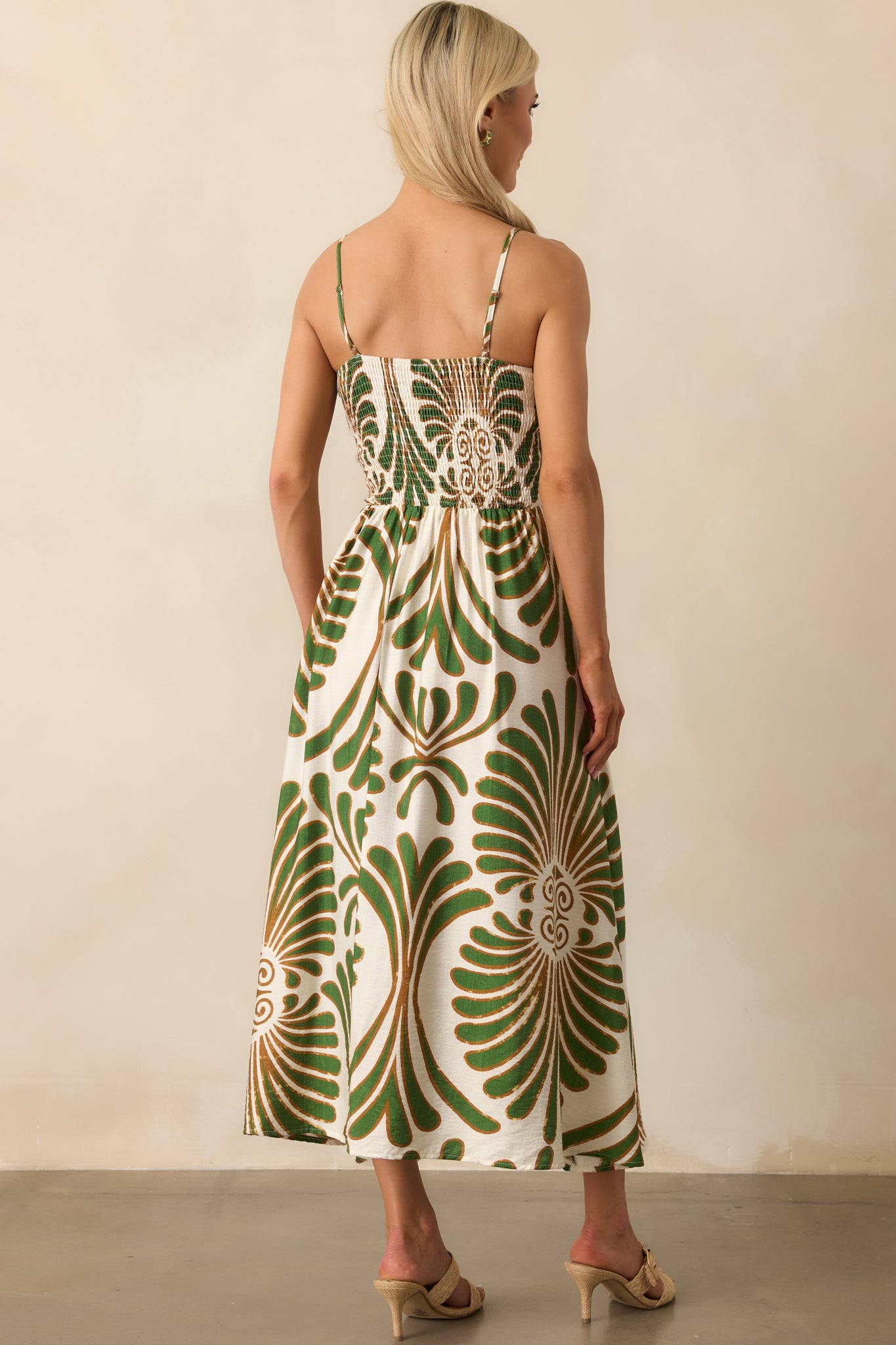 Back view of the dress displaying the continuation of the botanical print, slim adjustable straps, and the flow of the A-line silhouette from behind.
