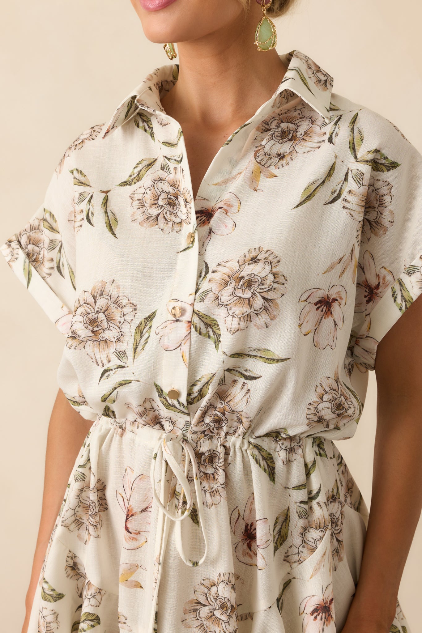 Close-up of the waistline and button placket, capturing the texture of the fabric, gold beaded tassels, and multicolor floral detailing.