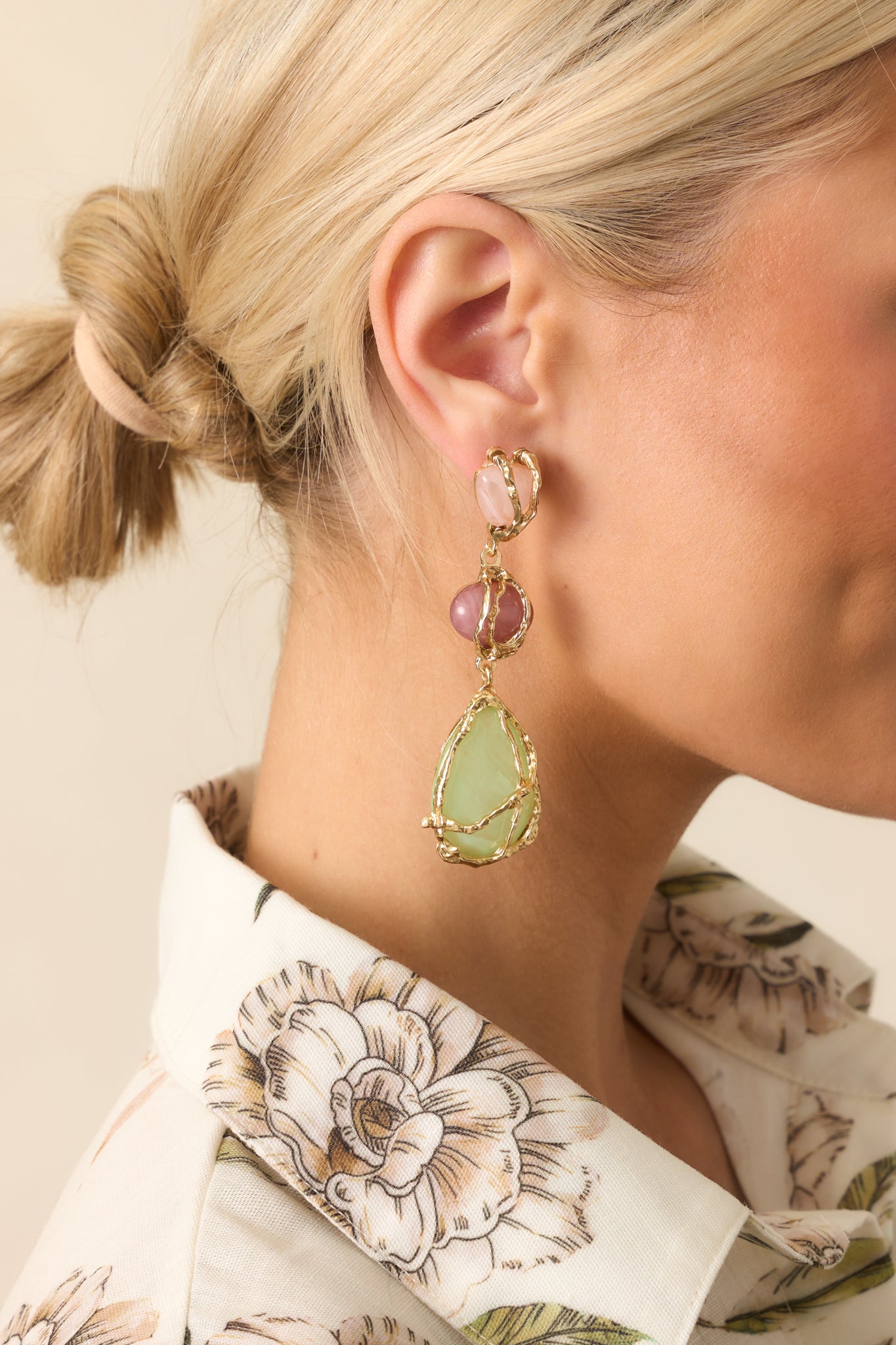 Cropped angled shot highlighting the drop dangle structure and textured gold wrapping around the colorful stones.