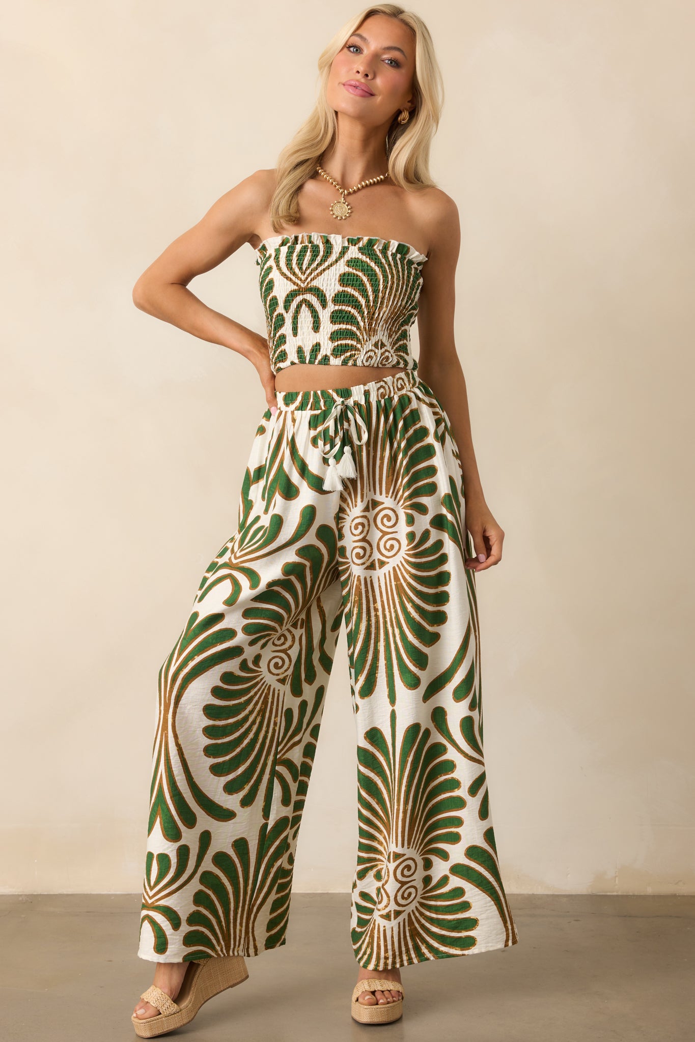 Full body front view showing the green abstract print top with a ruffle strapless neckline and fully smocked design.