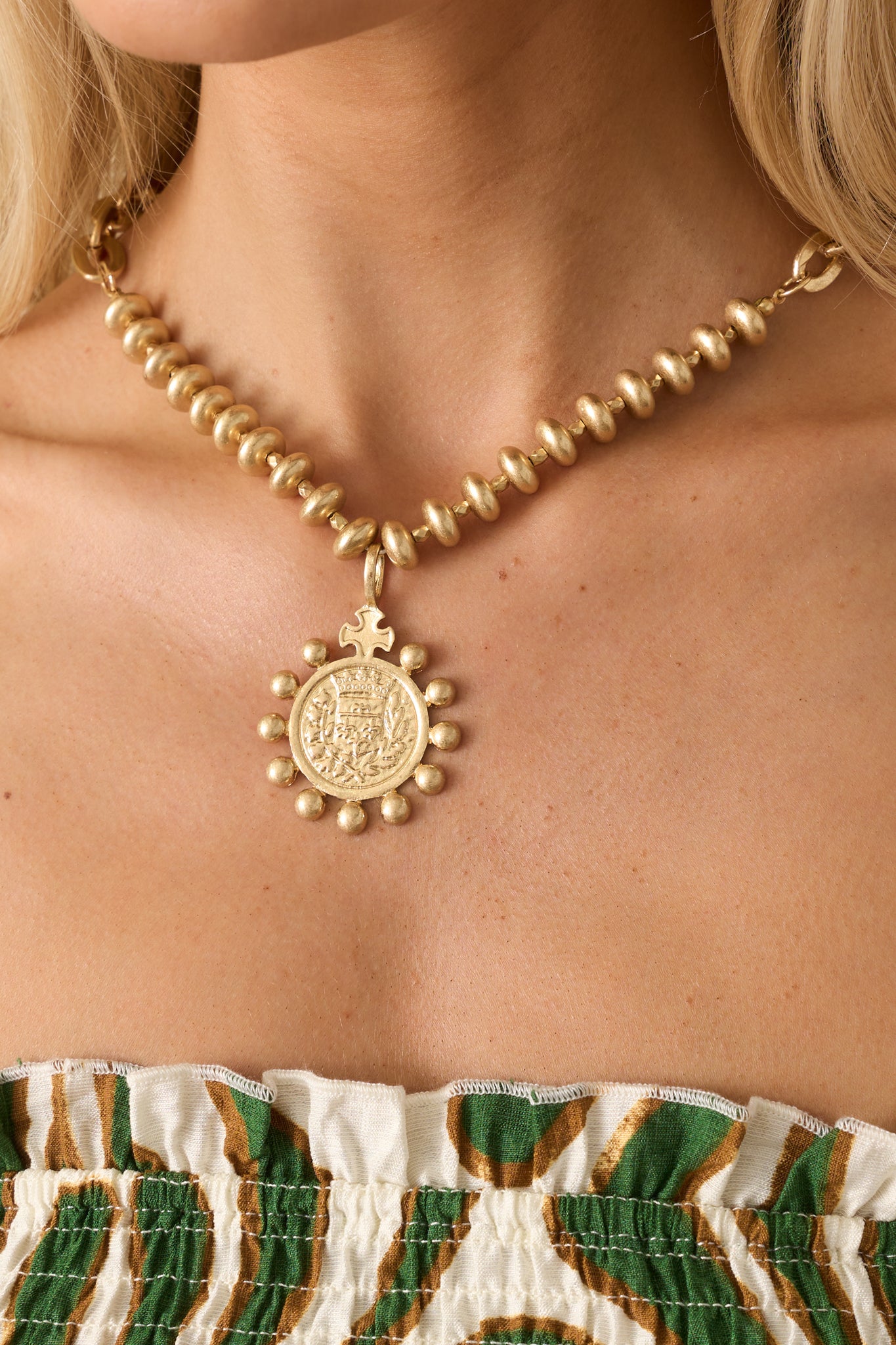 Cropped angled image focusing on the transition from the chain to the pendant, emphasizing texture and detail.