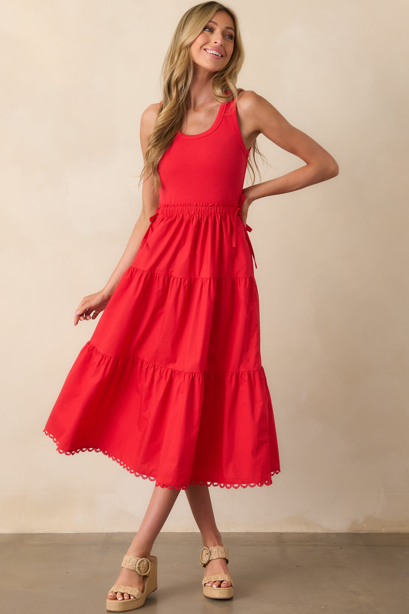 Front view of a red midi dress with a scoop neckline, ribbed bodice, and tiered skirt.