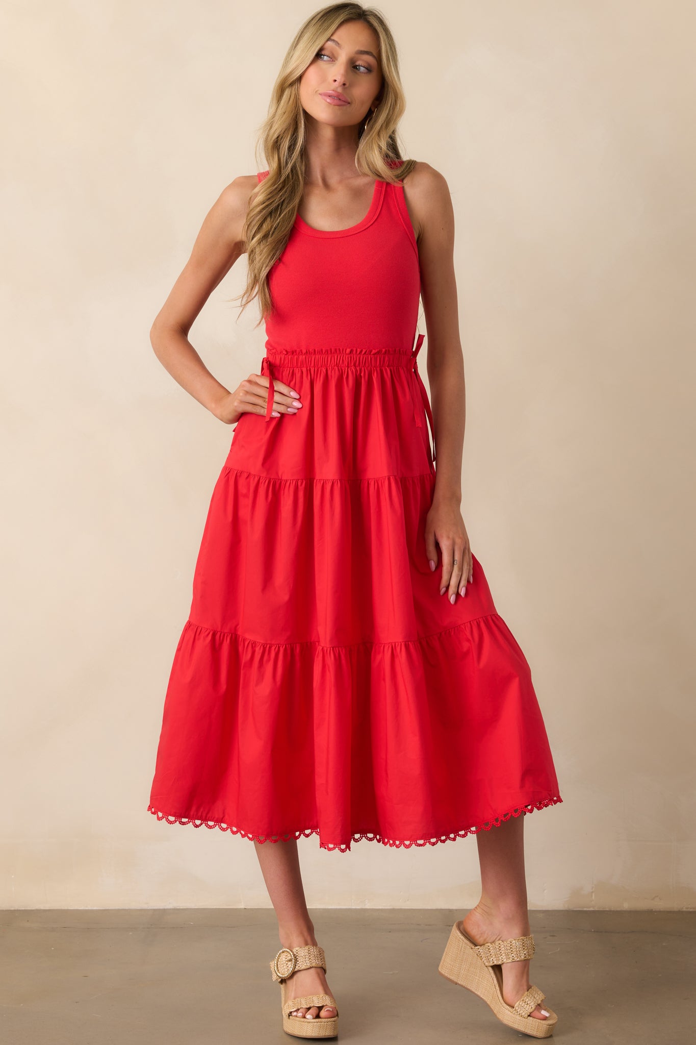 Front-facing image capturing the structure of the ribbed bodice and scalloped hemline of the red dress.
