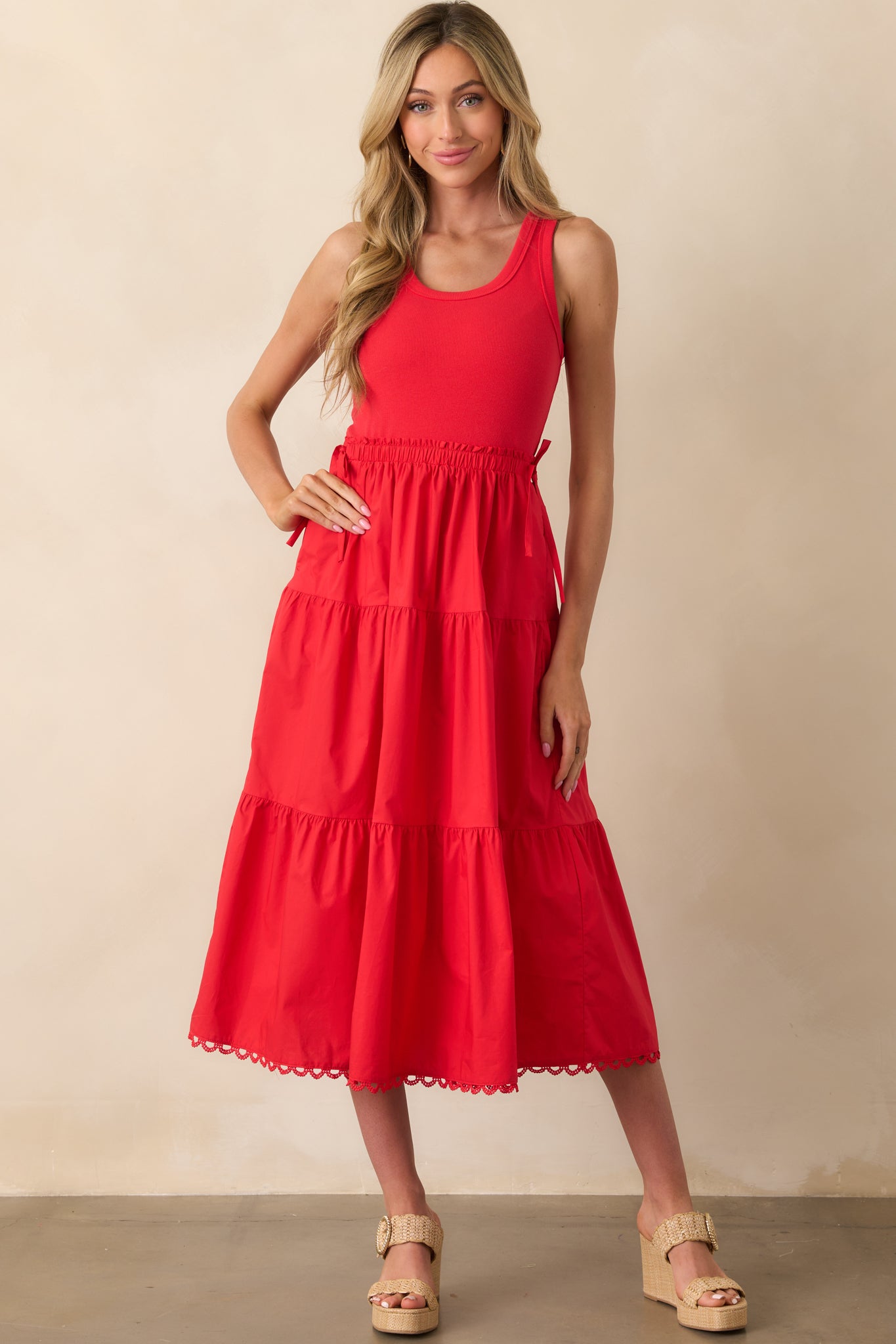 Three-quarter front angle of the red midi dress, emphasizing the textured tiering and waist detail.