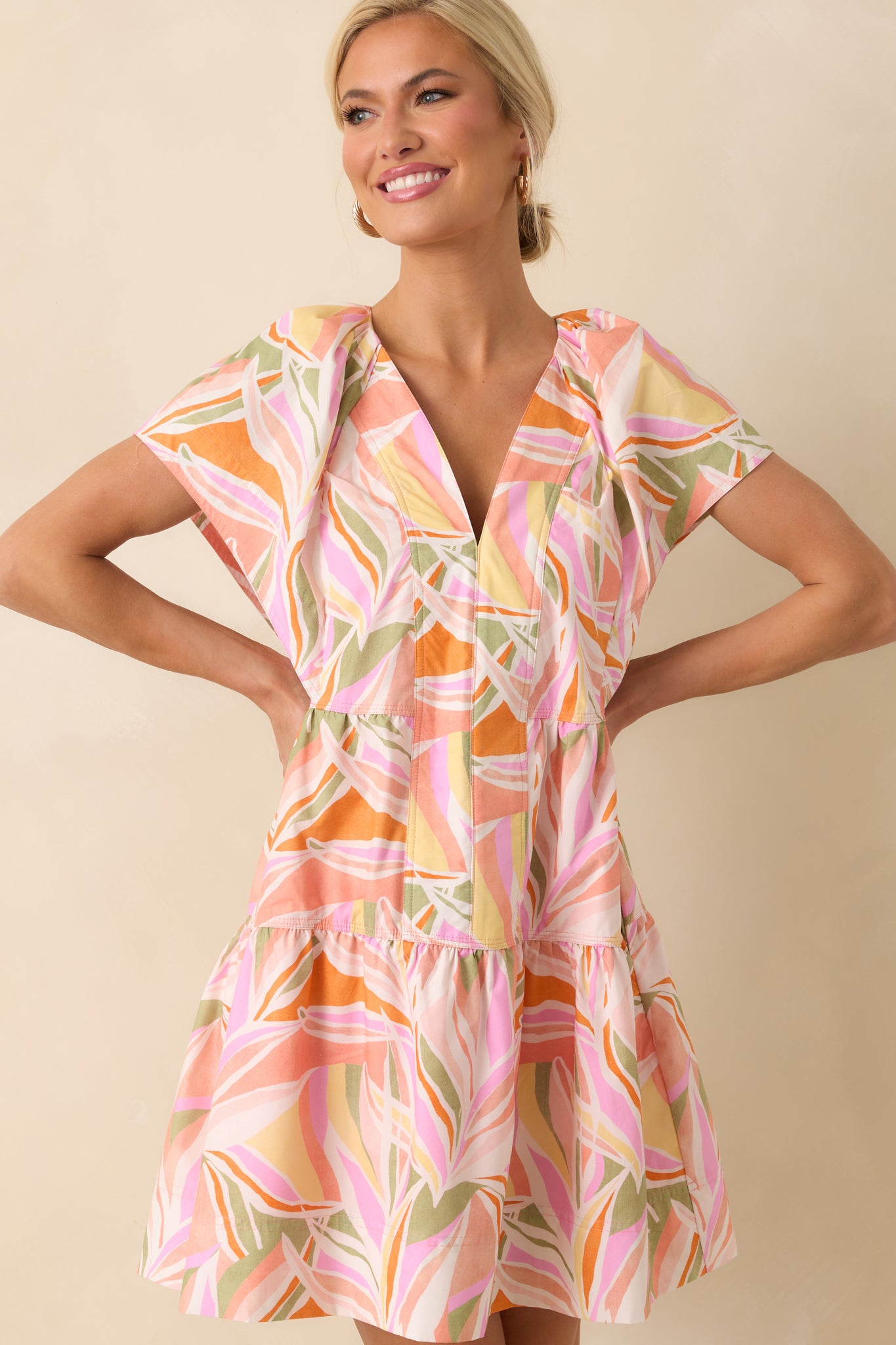 Cropped image focusing on the neckline and upper bodice, showing the v-neckline, sleeve ruffles, and floral pattern.