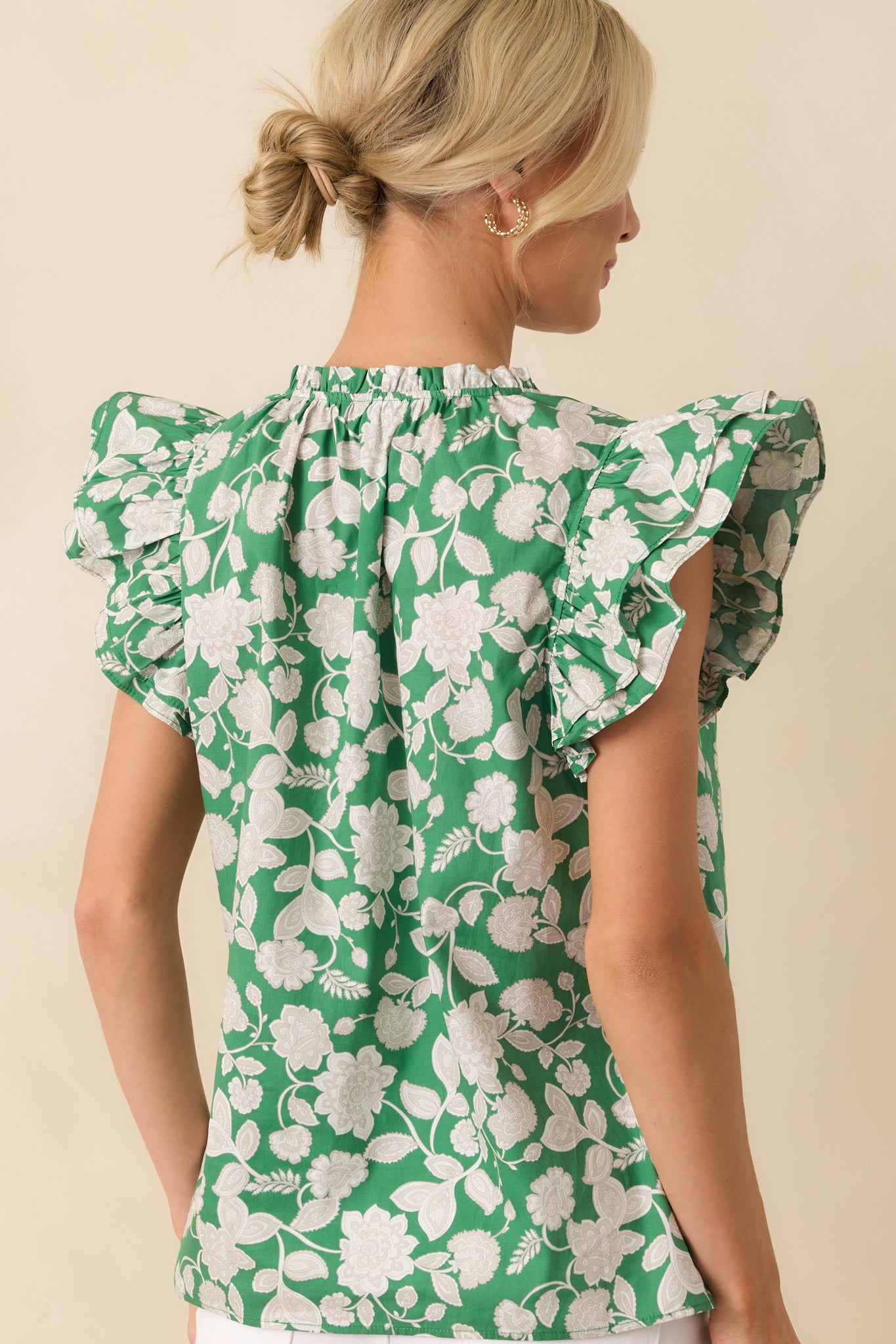 Back view of the top highlighting the continued paisley floral print, flutter sleeves, and relaxed, unstructured silhouette.