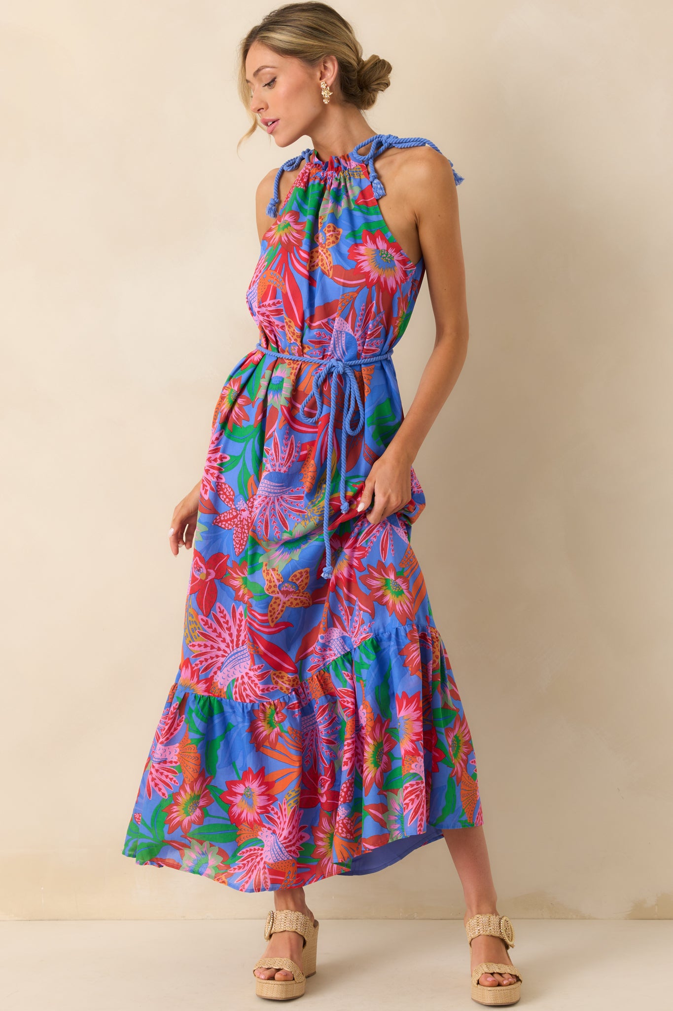 Front-facing full body view of the blue maxi dress featuring a pink multicolor tropical print and halter neckline.