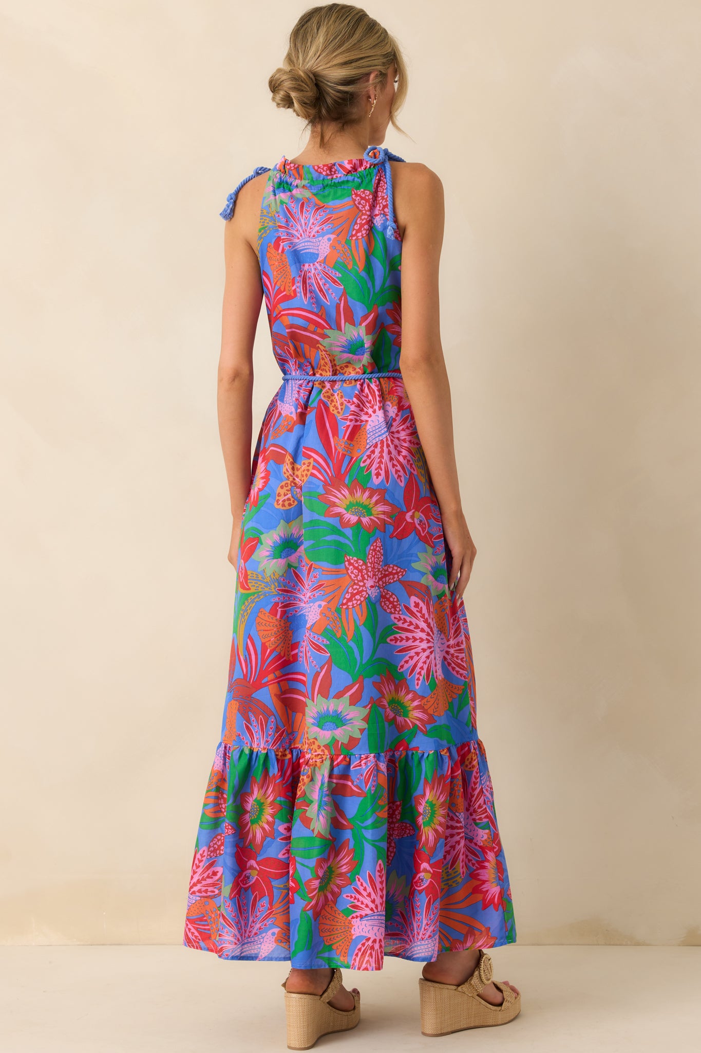 Back view of the dress showing the halter ties, exposed back design, and the continuation of the tropical print.