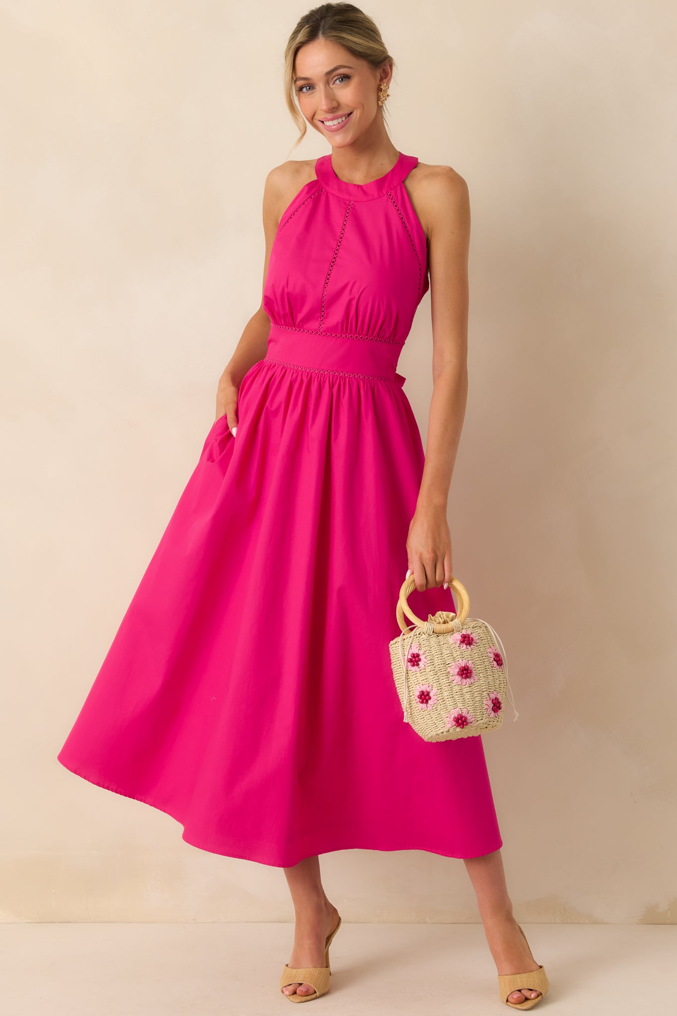 Fuchsia pink halter maxi dress shown highlighting the full length and functional pocket.