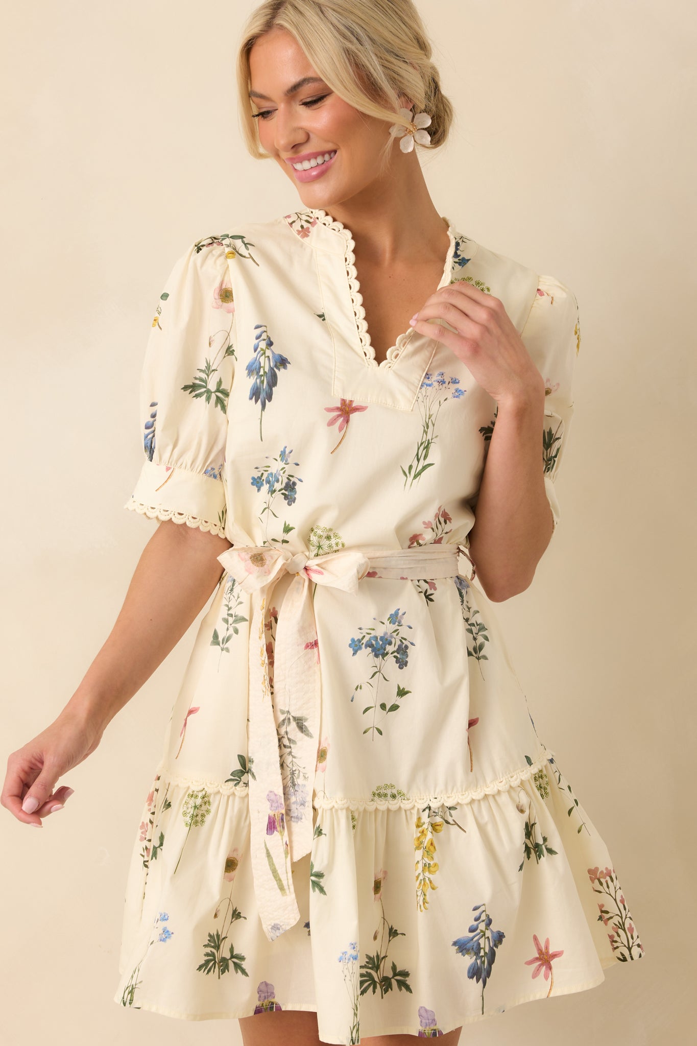 Cropped view of the neckline area, showing the notch v-neckline, puff sleeves, and ivory embroidered scallop trim.