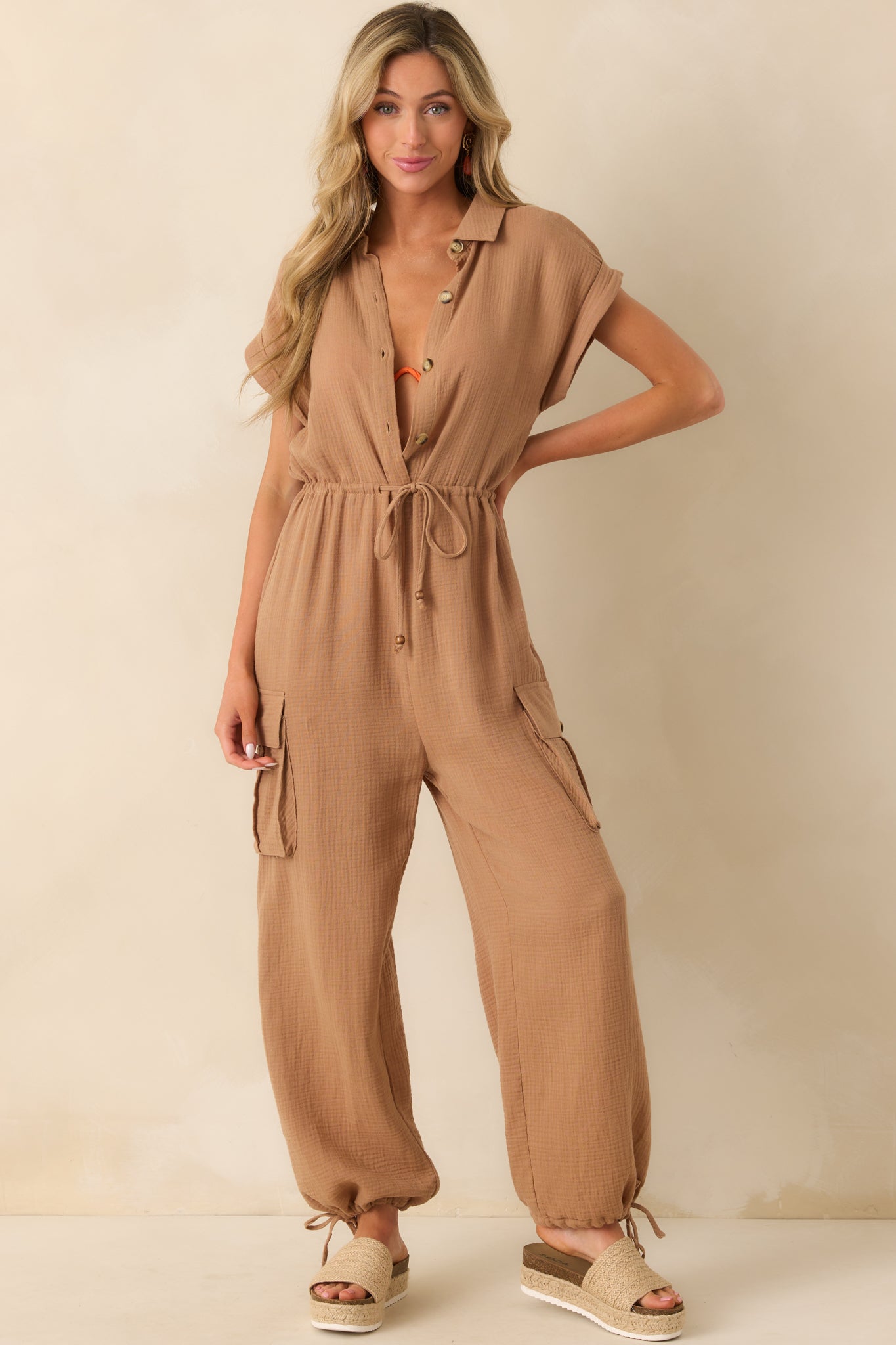 A full-body view highlighting the relaxed drape, buttoned utility pockets at the hips, and drawstring waist detail.