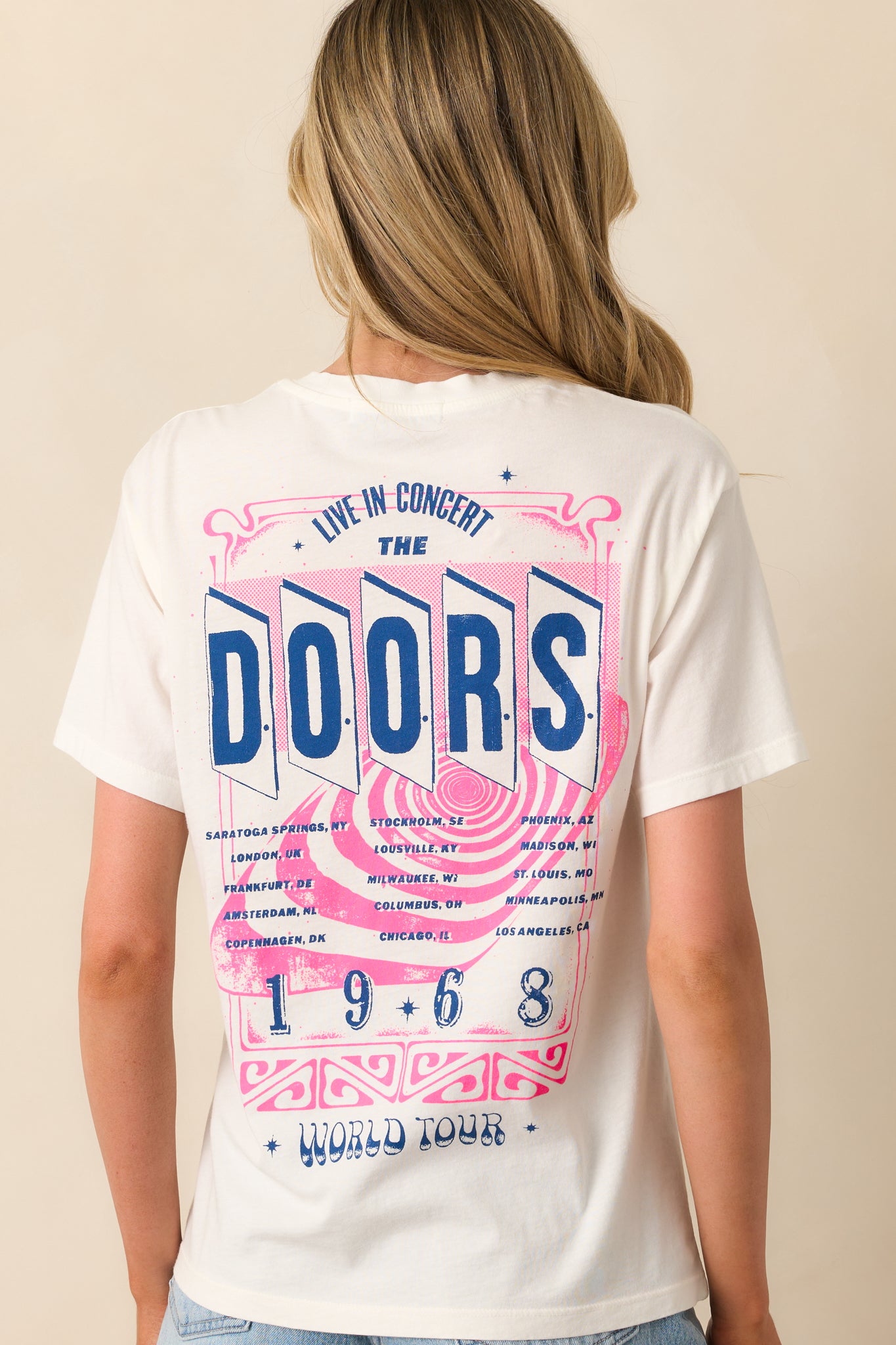 View from behind of the white tee showing the tour details printed on the back, with short sleeves and relaxed fit.