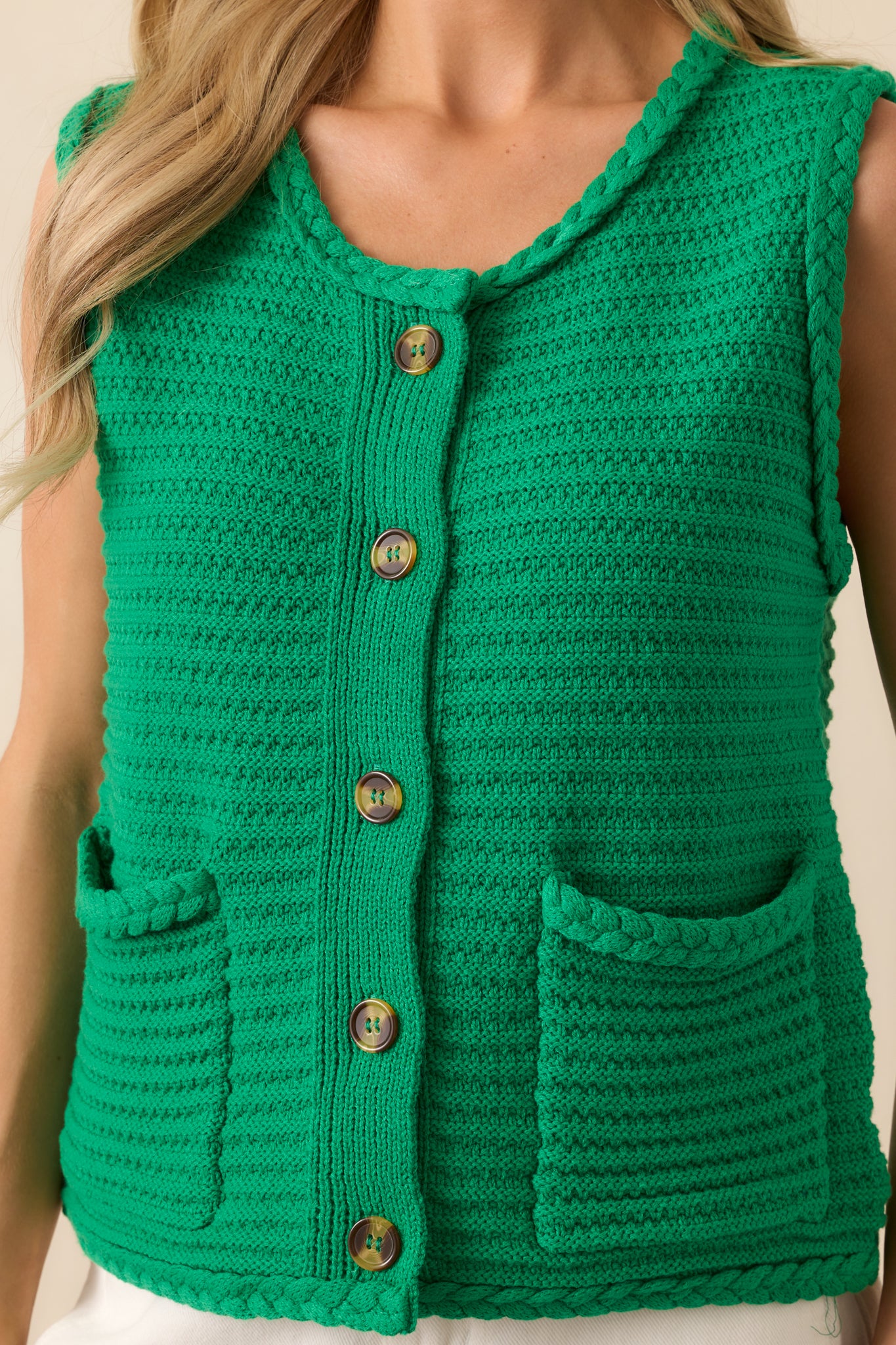 Detail shot of the knit fabric with braided trim and tortoise shell button accent.