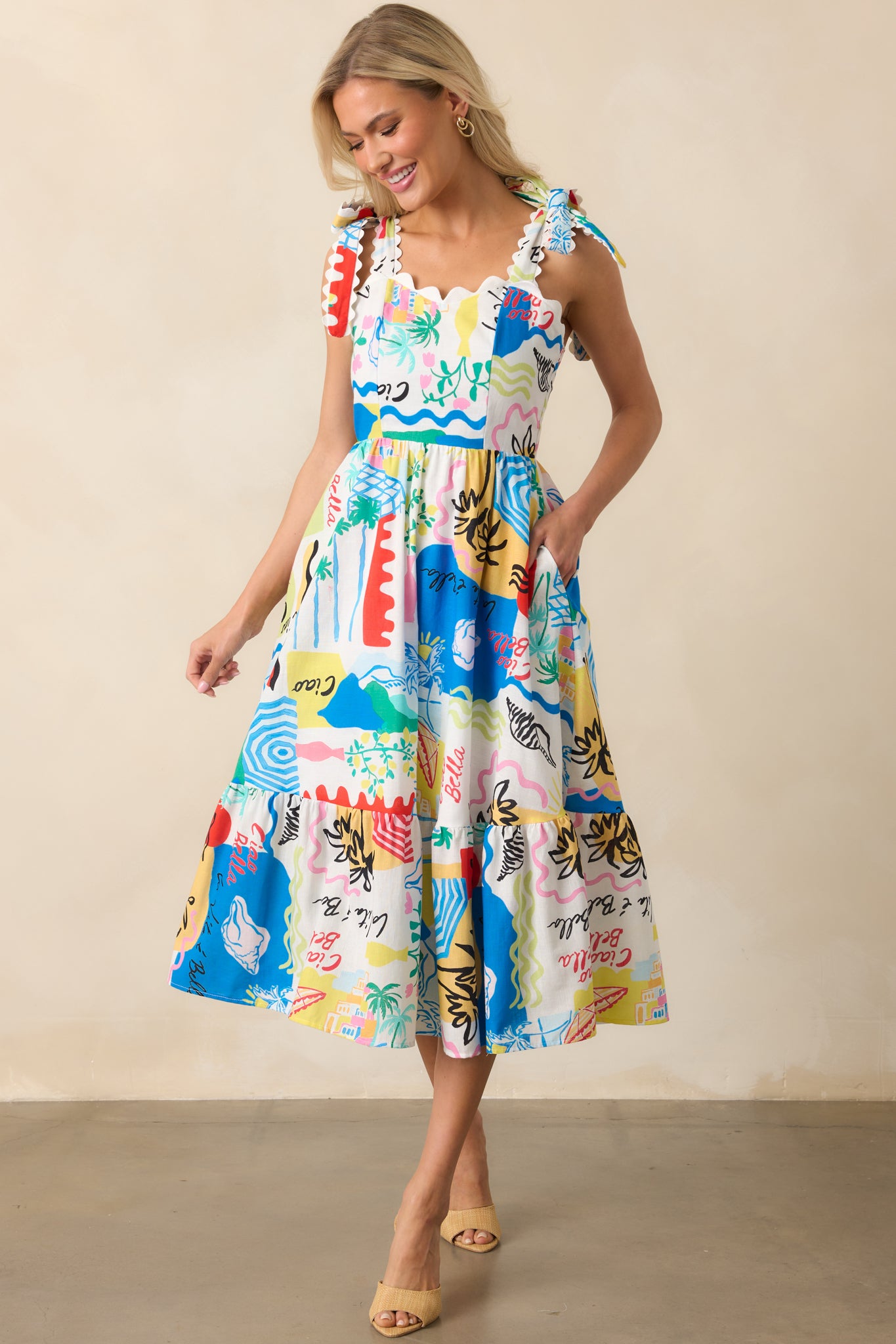 The multi tropical print dress with self-tie shoulder straps, white scallop detailing on the straps and top trim, shown in full front view highlighting the vibrant tropical pattern.
