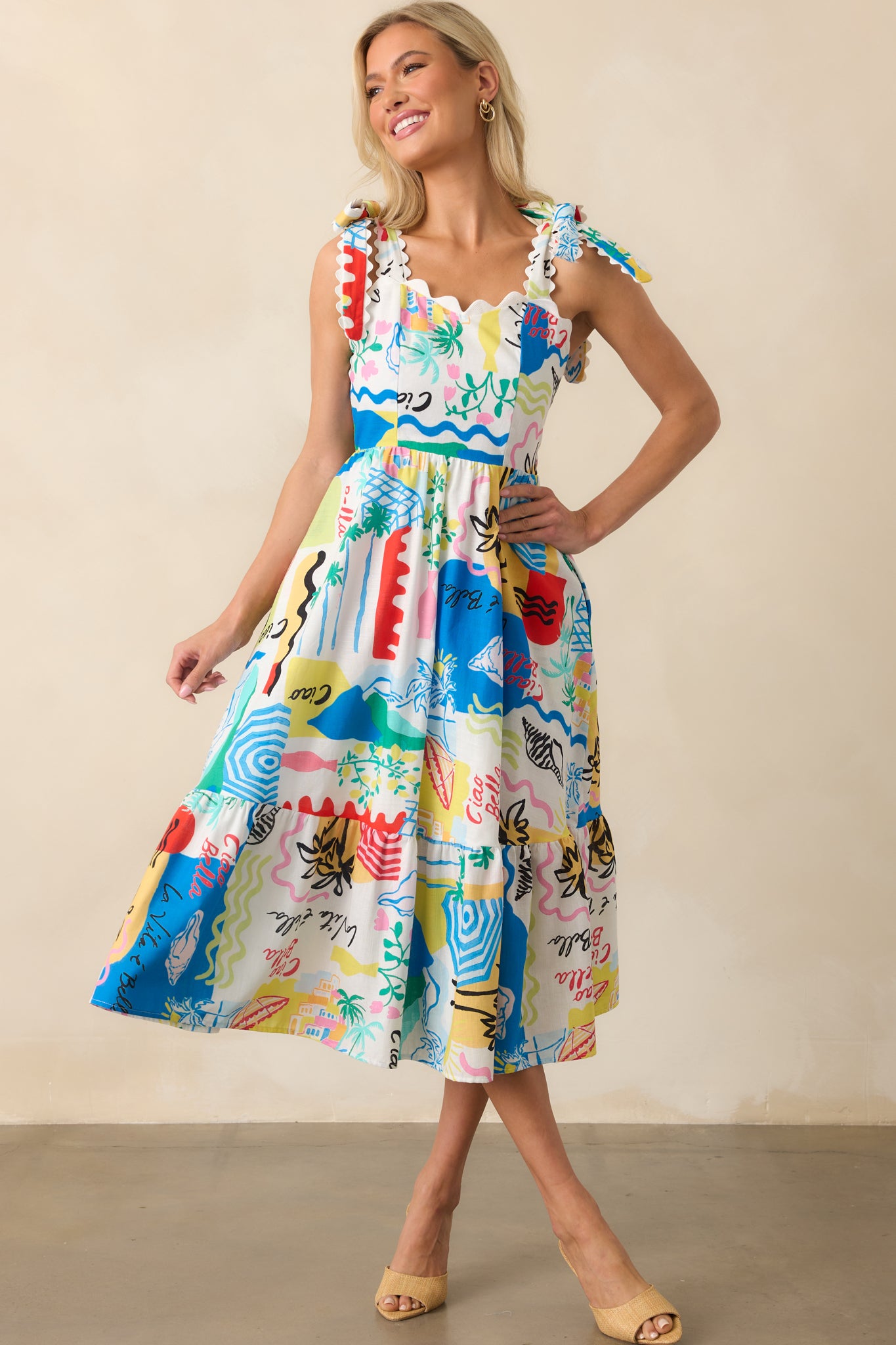 Another front view of the dress, showcasing the fitted bodice, the scalloped top edge, and the flowy skirt with tropical print.
