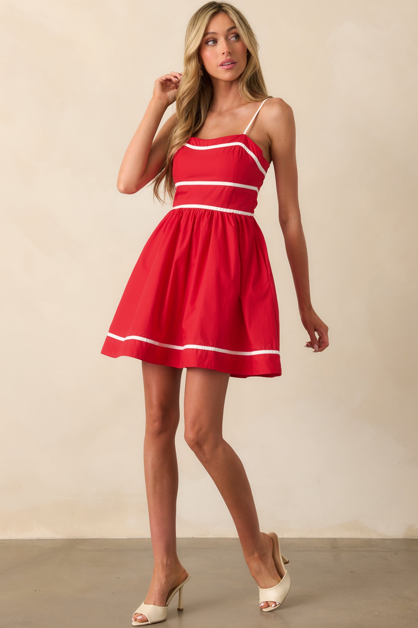 Mini dress with smocked back panel and decorative white piping that outlines the structured bodice.