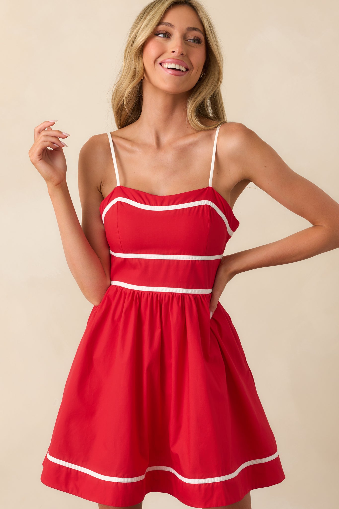 Close-up of the dress’s white piping trim along the neckline and waist, adding sharp contrast to the red fabric.