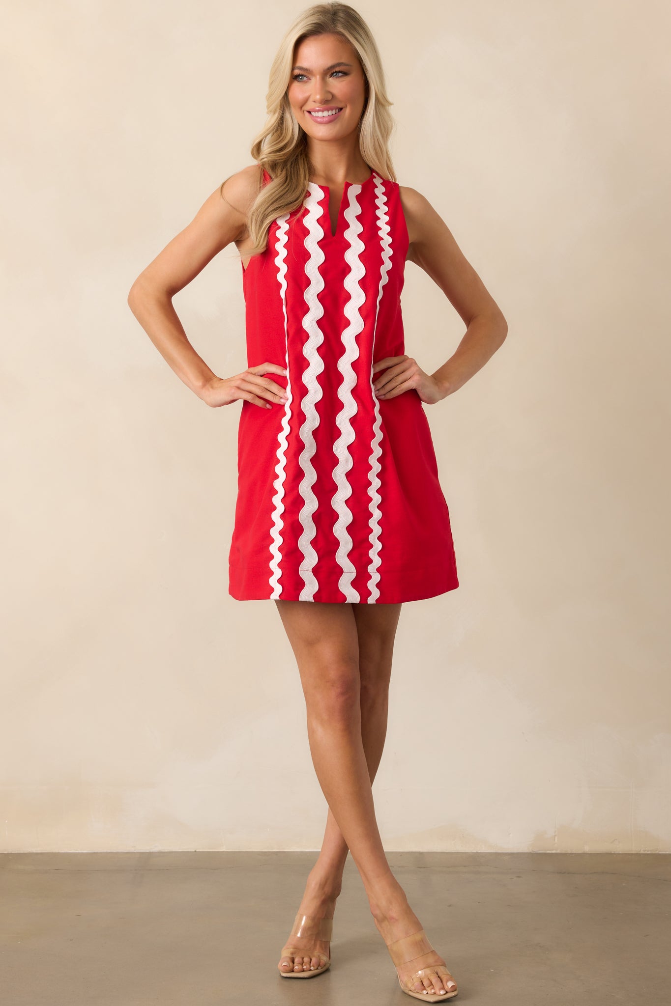 Shift dress in bold red with functional side pockets and a clean, minimal silhouette accented by white ric rac.
