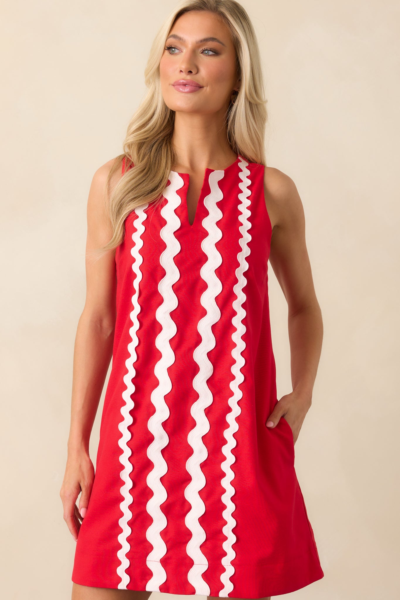 Focus on one of the side pockets and the smooth, clean lines of the shift dress, highlighting the red fabric.