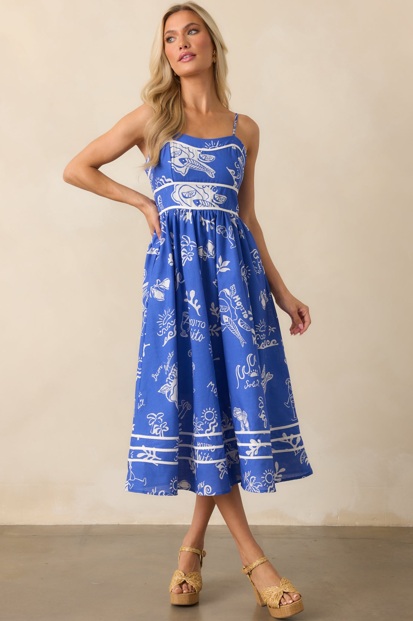 Blue dress with adjustable straps and a mid-length hem, highlighting the playful mojito design across the fabric.