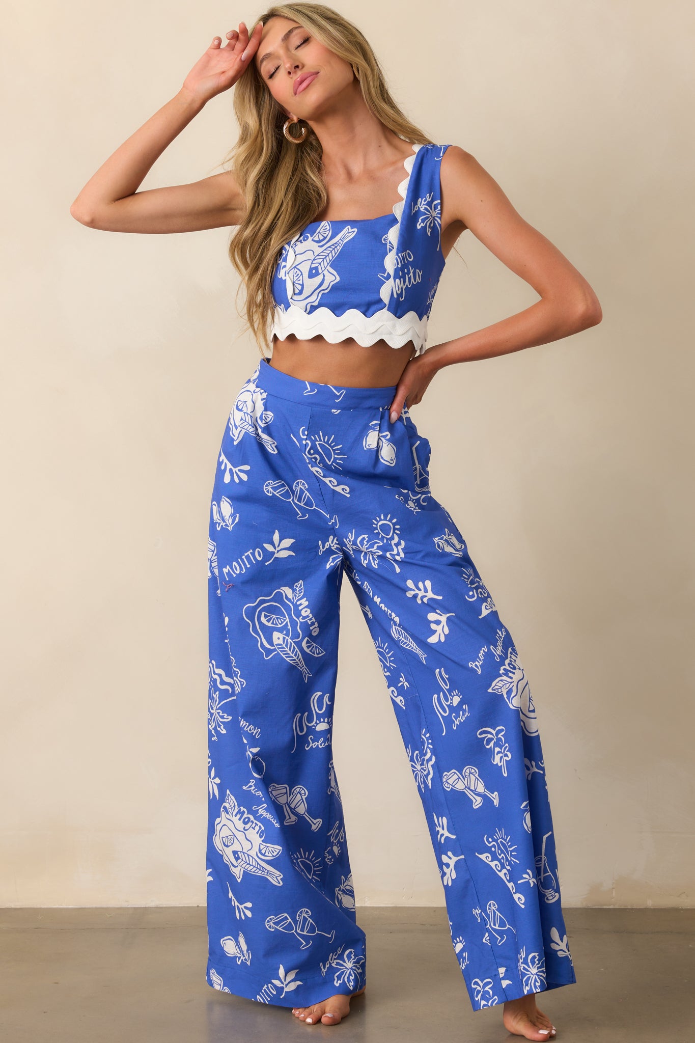 A complete front view of blue pants styled with side pockets visible and a relaxed drape through the wide leg design.